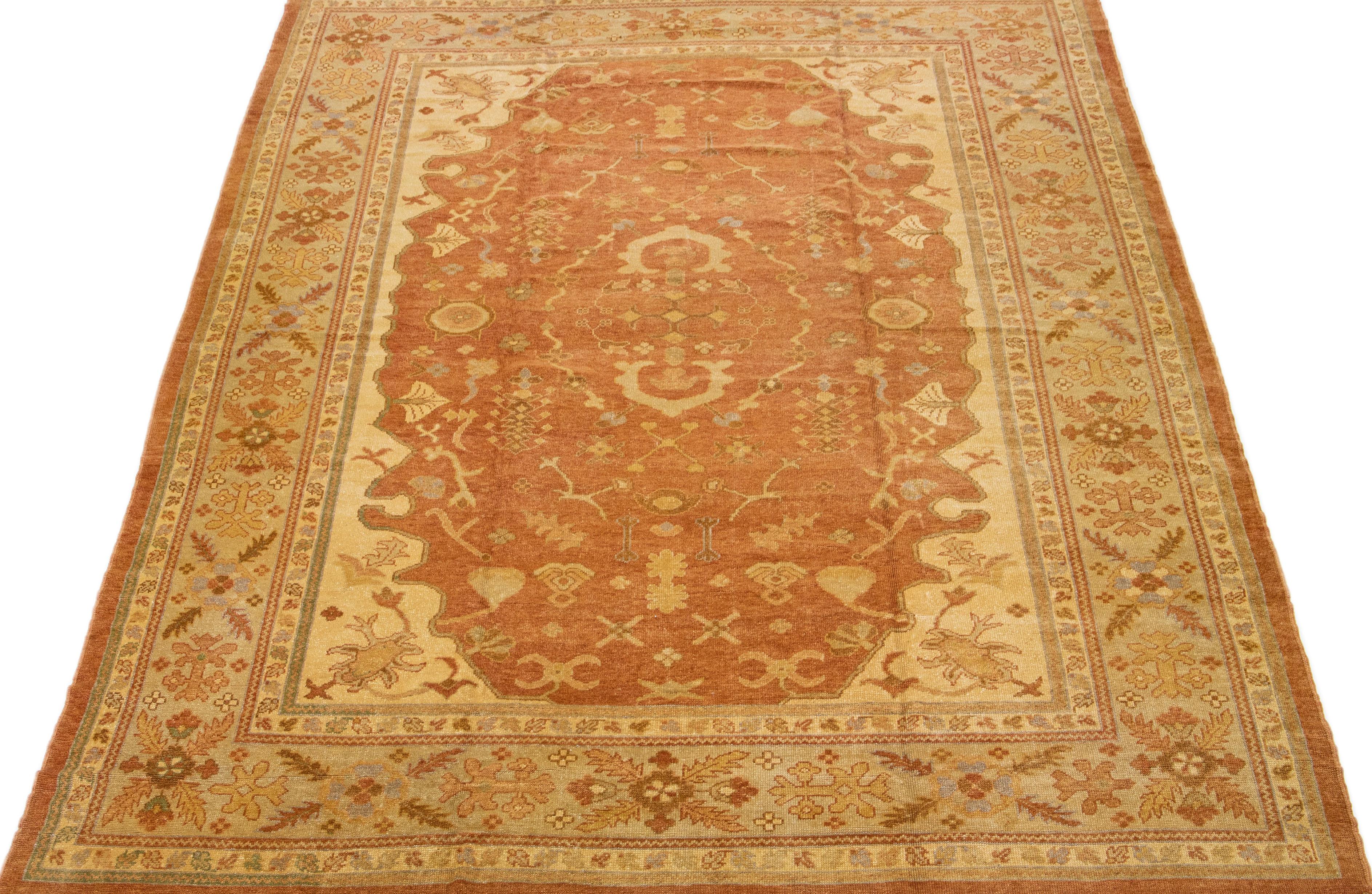 Beautiful modern Turkish hand-knotted wool rug with a copper color field. This rug has a blue-designed frame with accent colors of gray in a gorgeous all-over floral design.

This rug measures: 12'2