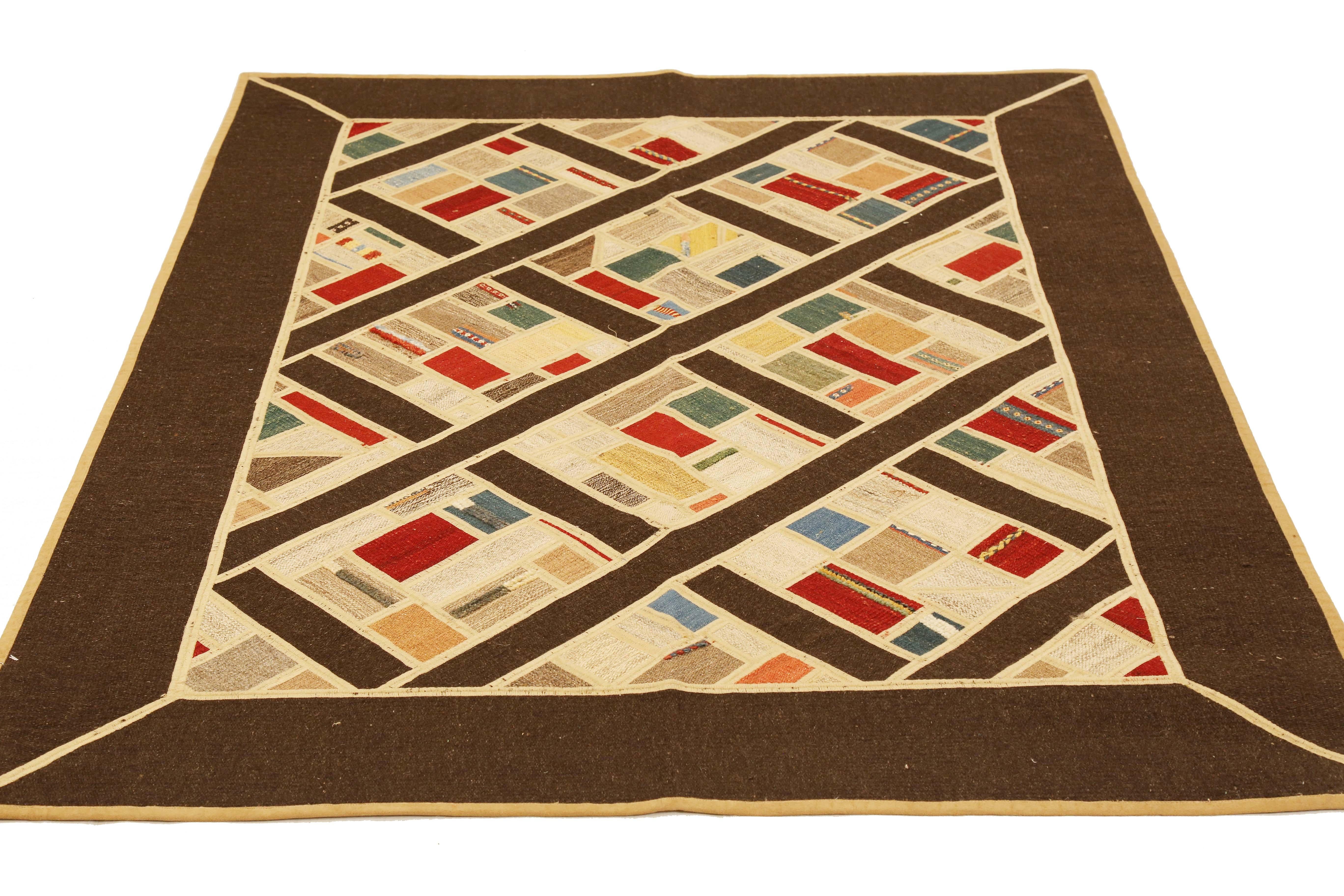 Modern Turkish rug handwoven from the finest sheep’s wool and colored with all-natural vegetable dyes that are safe for humans and pets. It’s a traditional Patch Kilim flat-weave design featuring colored squares on a brown field. It’s a stunning