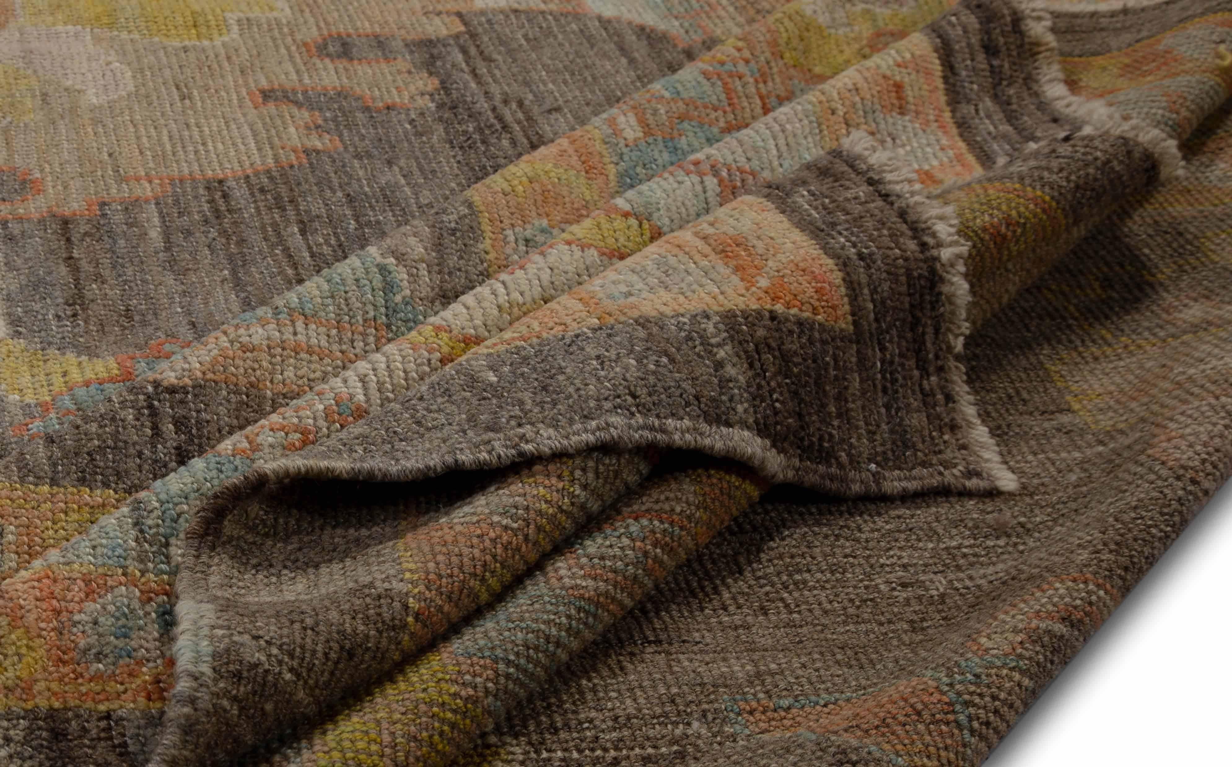 Tapis moderne turc en laine de mouton tissée à la main de la meilleure qualité. Il est coloré avec des teintures végétales biologiques certifiées sans danger pour les humains et les animaux de compagnie. Il présente un champ central brun avec des