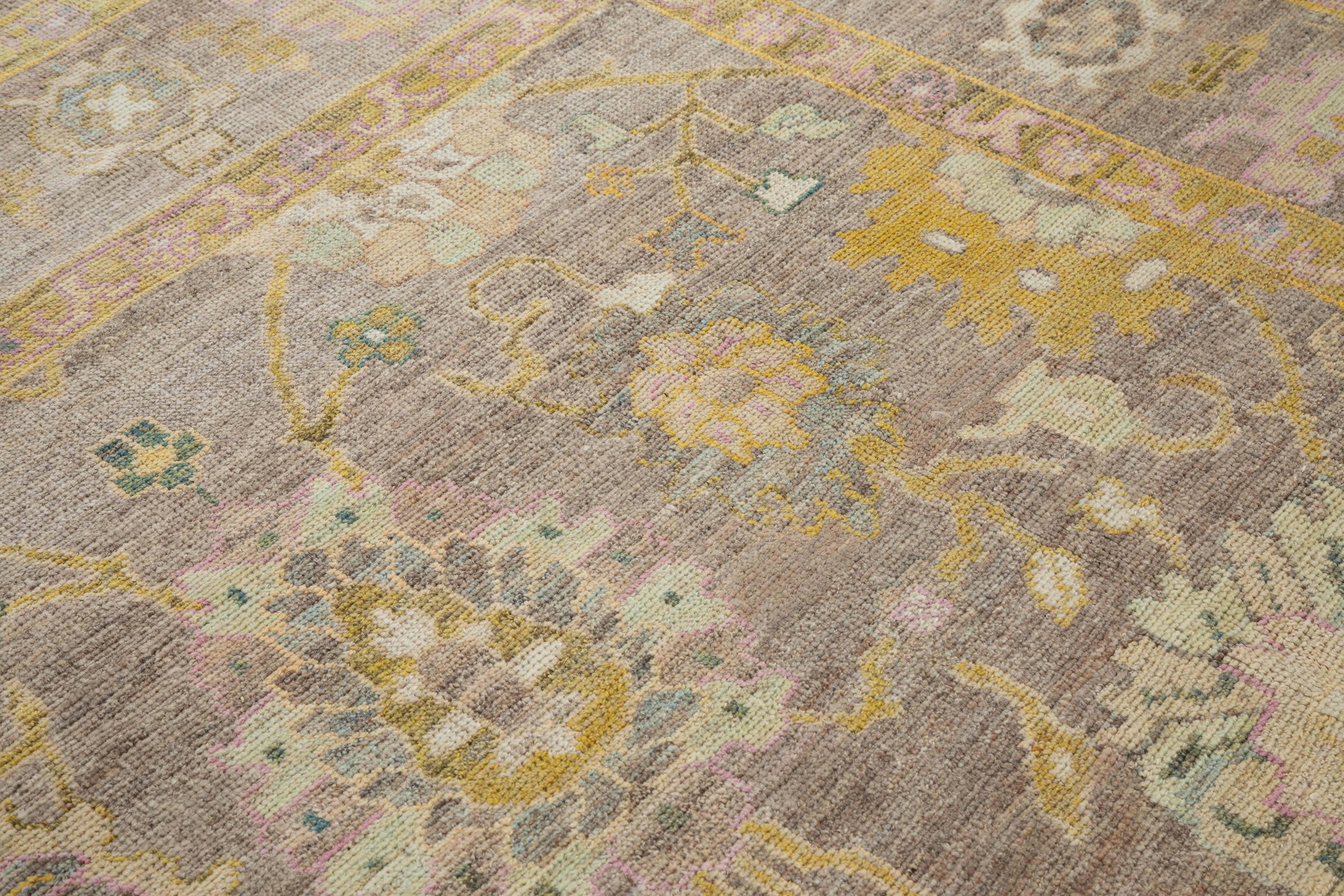 Modern Turkish area rug made of handwoven sheep’s wool of the finest quality. It’s colored with organic vegetable dyes that are certified safe for humans and pets alike. It features a brown field with allover floral patterns in pink, green and gold