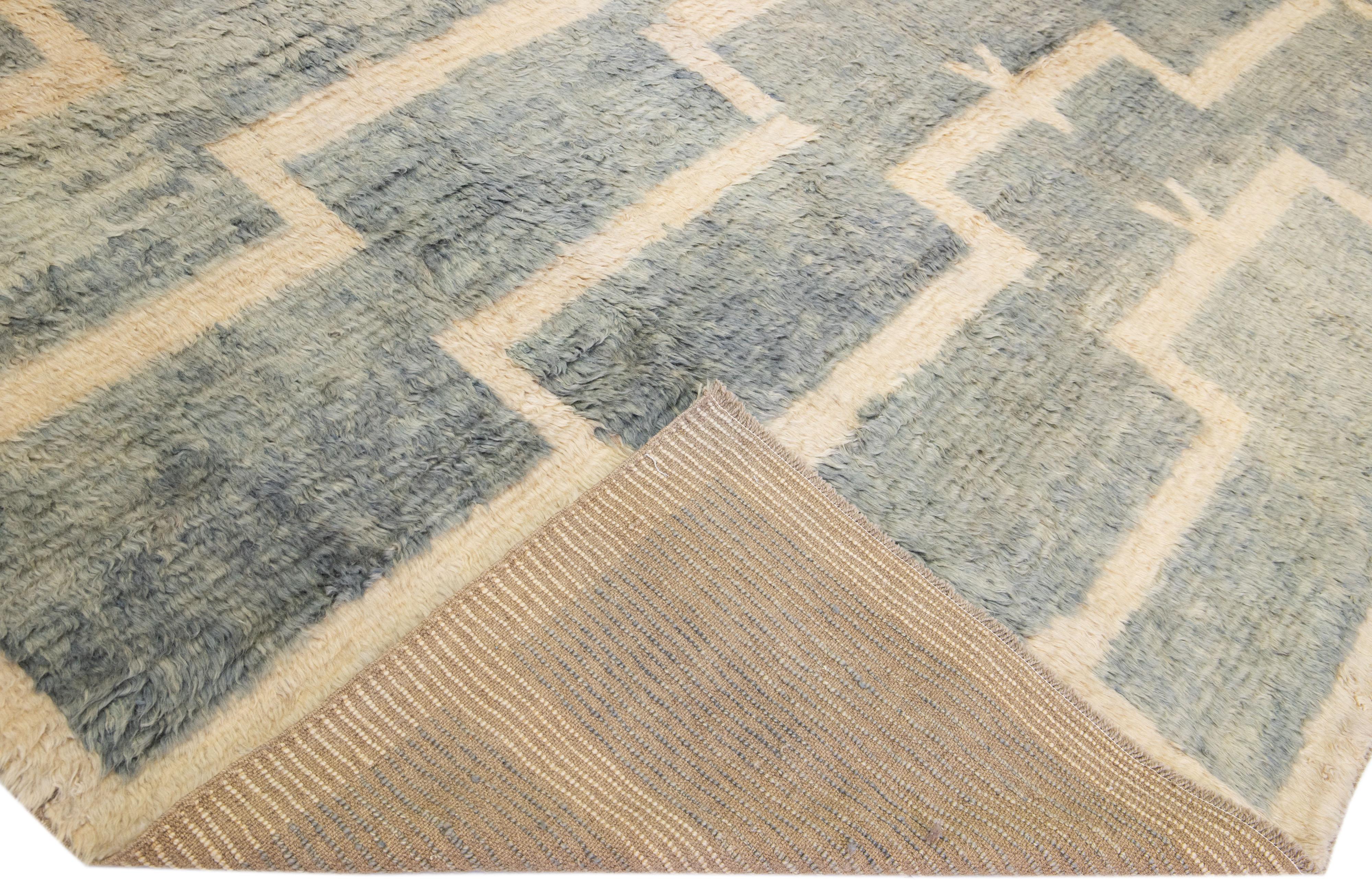 Beautiful modern Tulu hand-knotted wool rug with a gray-blue color field. This Tulu rug has beige accents in a gorgeous geometric design. 

This rug measures: 13'6