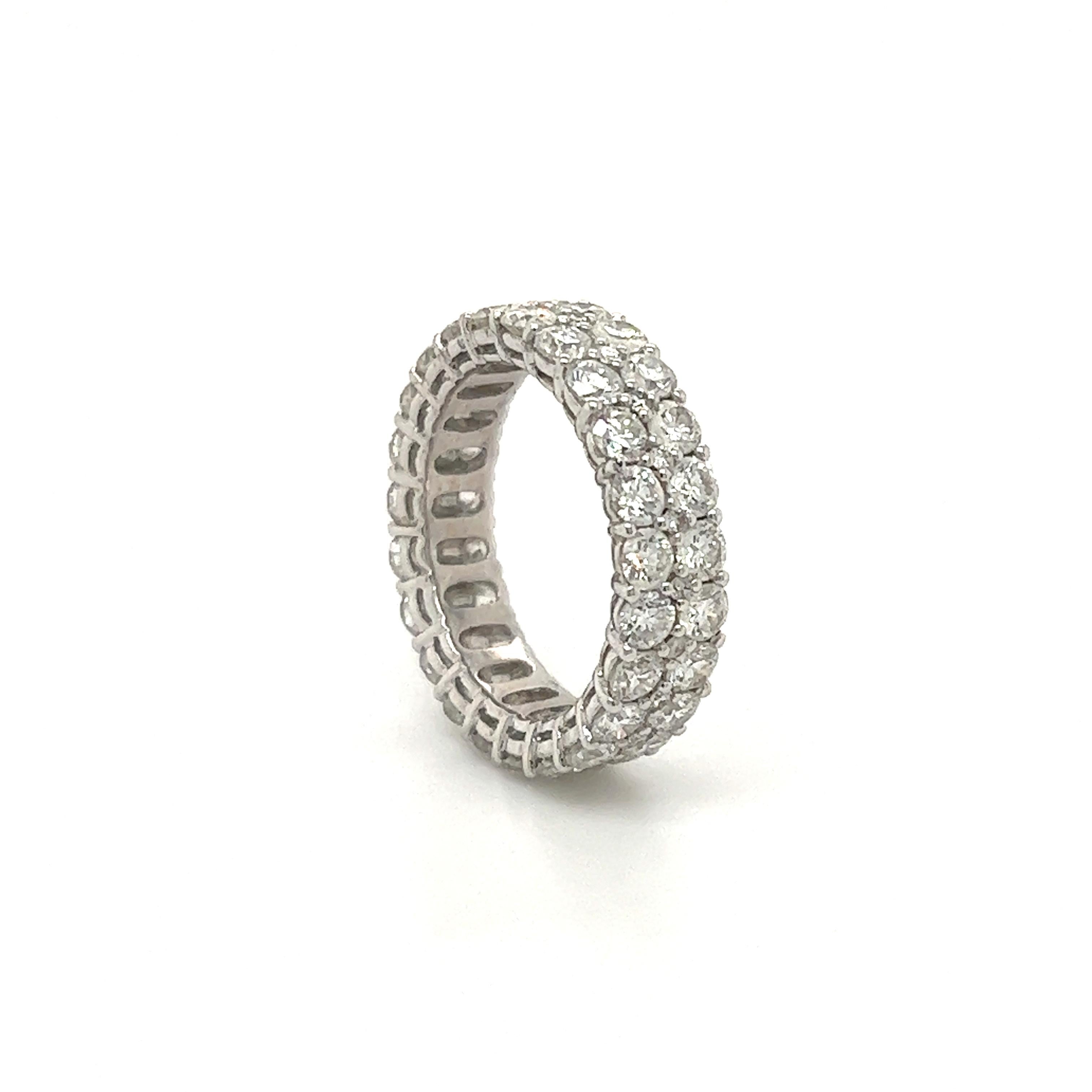 Fantastic design seen on this modern diamond eternity band. The ring is crafted in 18k white gold and showcases two rows of round brilliant cut diamonds, approximately 4.50 carat. The diamonds all show G-H color and VS clarity. The ring shows small