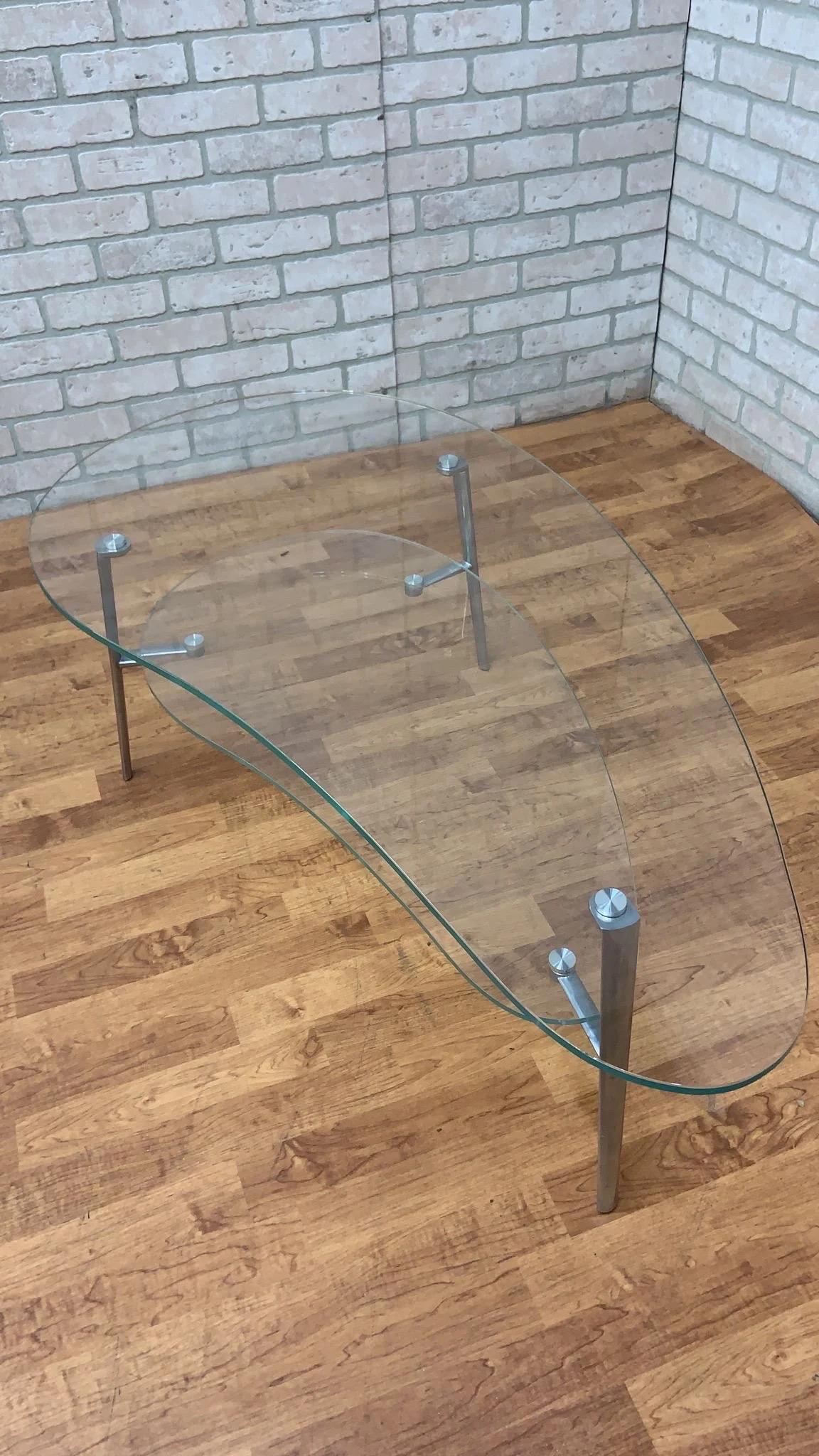 Modern Two-Tier Kidney Shape Glass and Metal Coffee Table

Embrace minimalism with this sleek coffee table made almost completely from glass. The classic biomorphic or kidney shaped glass lends itself to an organic feel while embracing the minimal