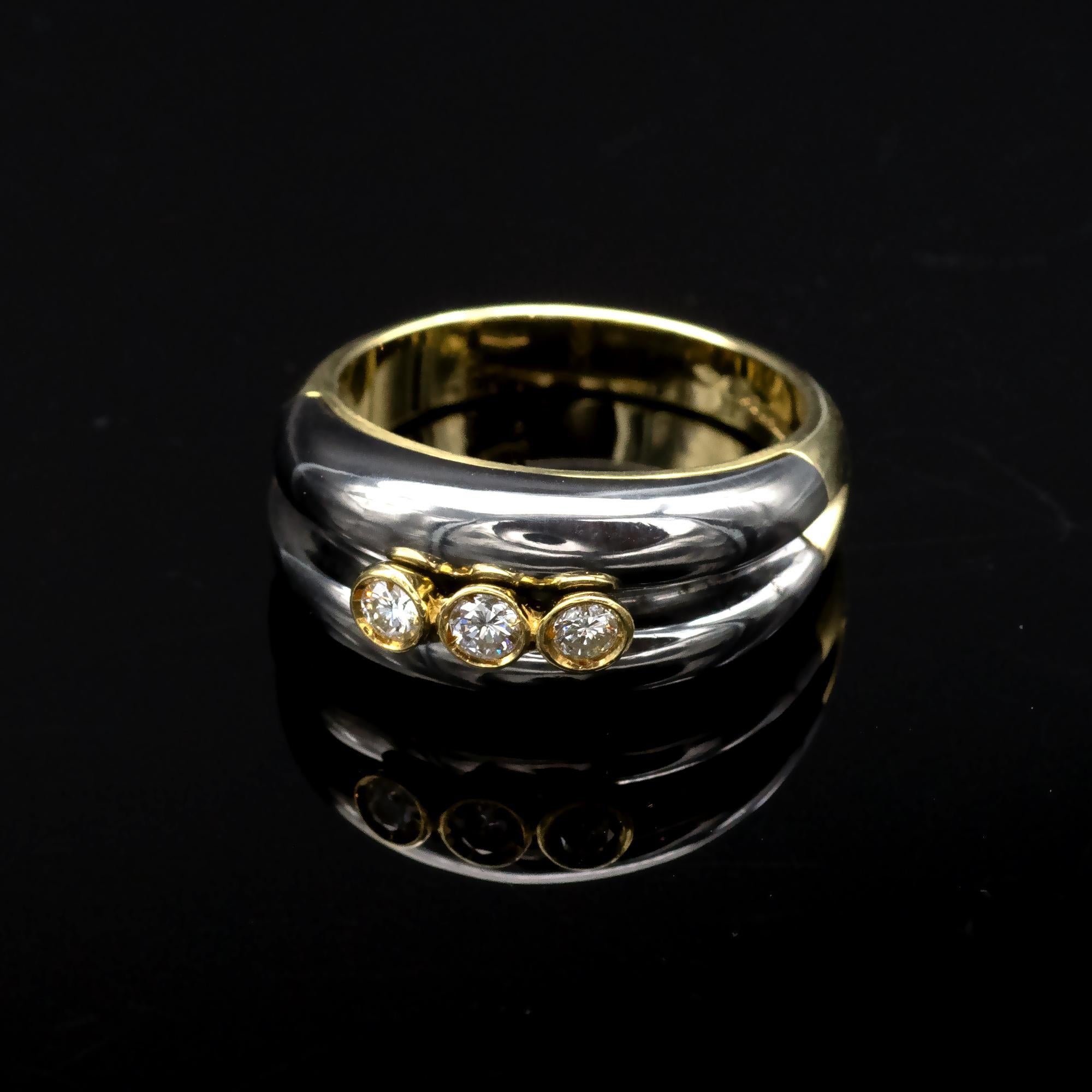 Stylish two tone - yellow a black rhodium 18 Karat gold - diamond ring.
Three diamonds are bezel set in a yellow gold element inlayed in a polished black rhodium gold. The ring is made of several elements expertly adjusted and assembled. 
The design