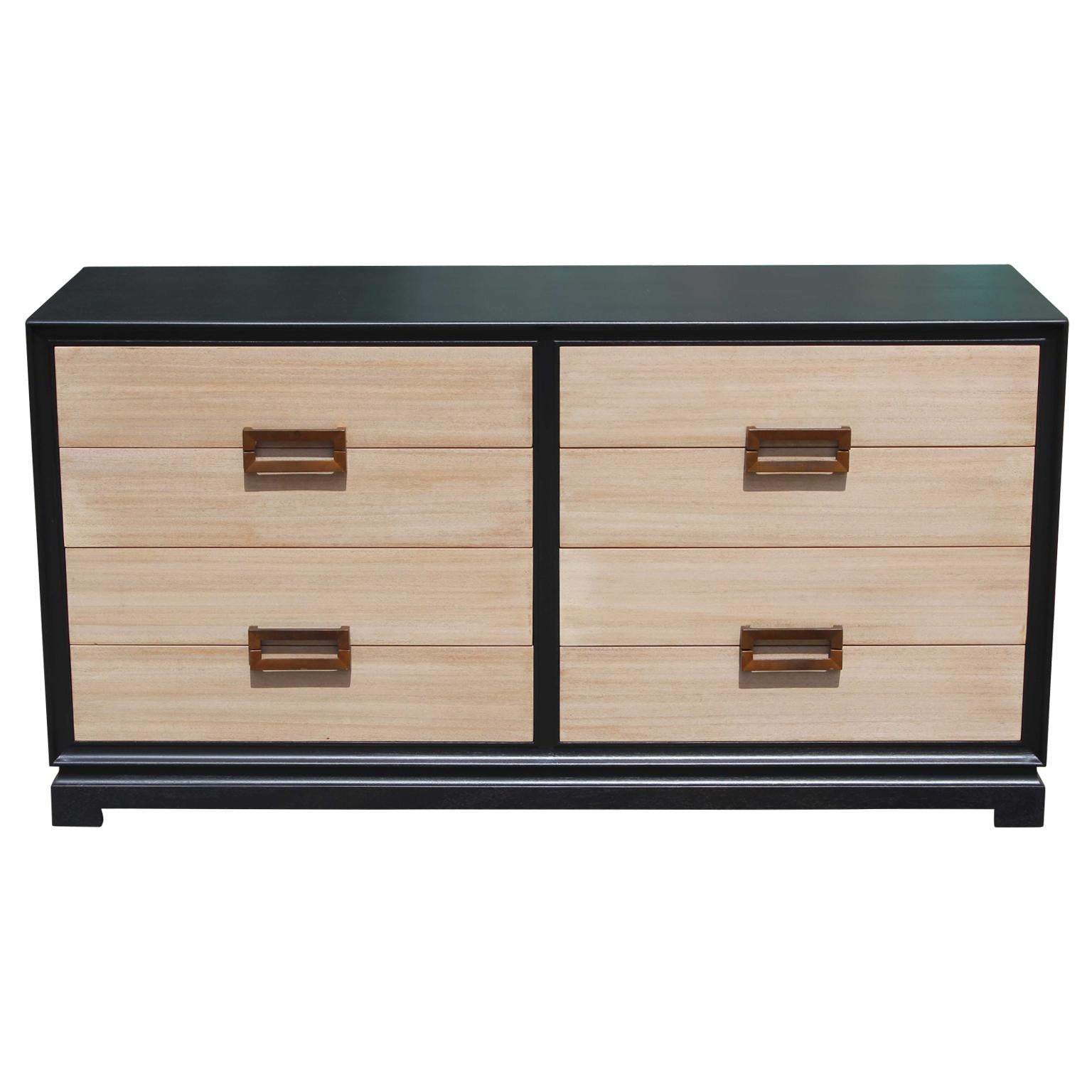 Modern two-tone eight-drawer dresser with a neutral finish on the front of the drawers with brass pulls. In the style of Grosfeld House or Dunbar.