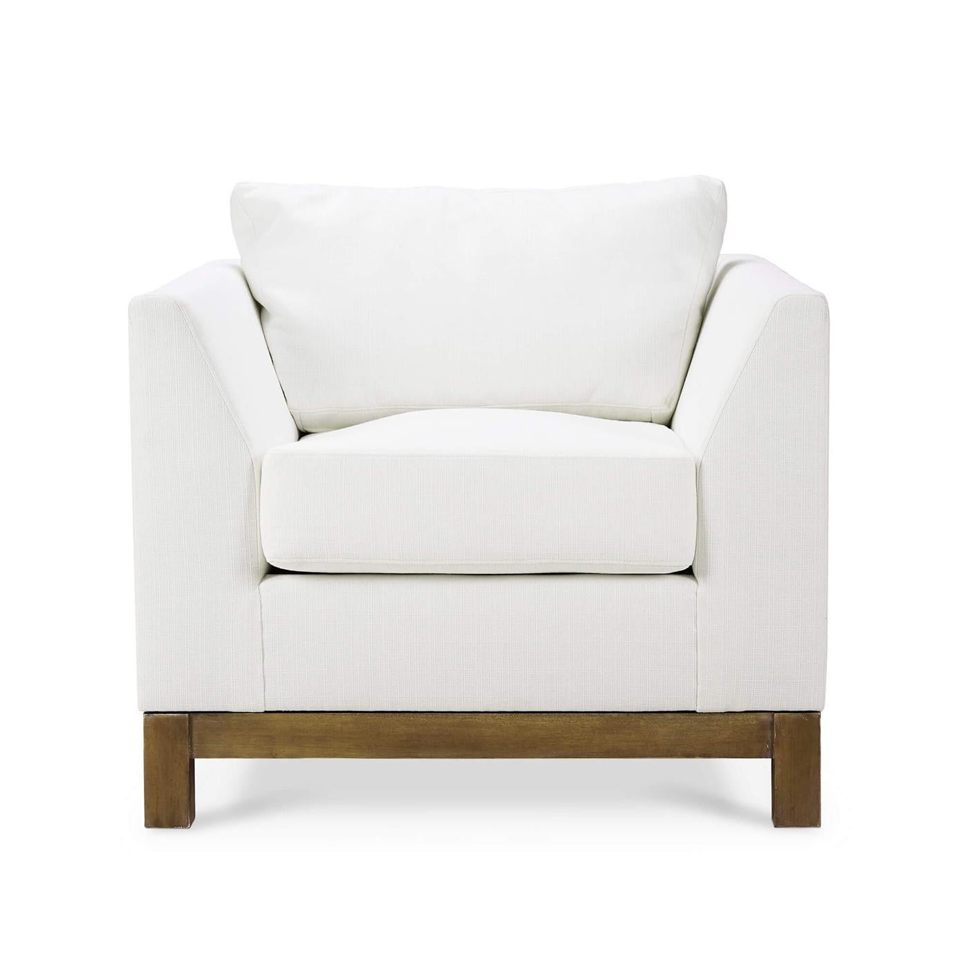 Una mezcla perfecta de diseño minimalista y lujoso confort. Este exquisito sillón presenta un armazón elegante y anguloso tapizado en tejido de alto rendimiento blanco ártico, que aporta elegancia y durabilidad. La sencilla base de madera maciza,