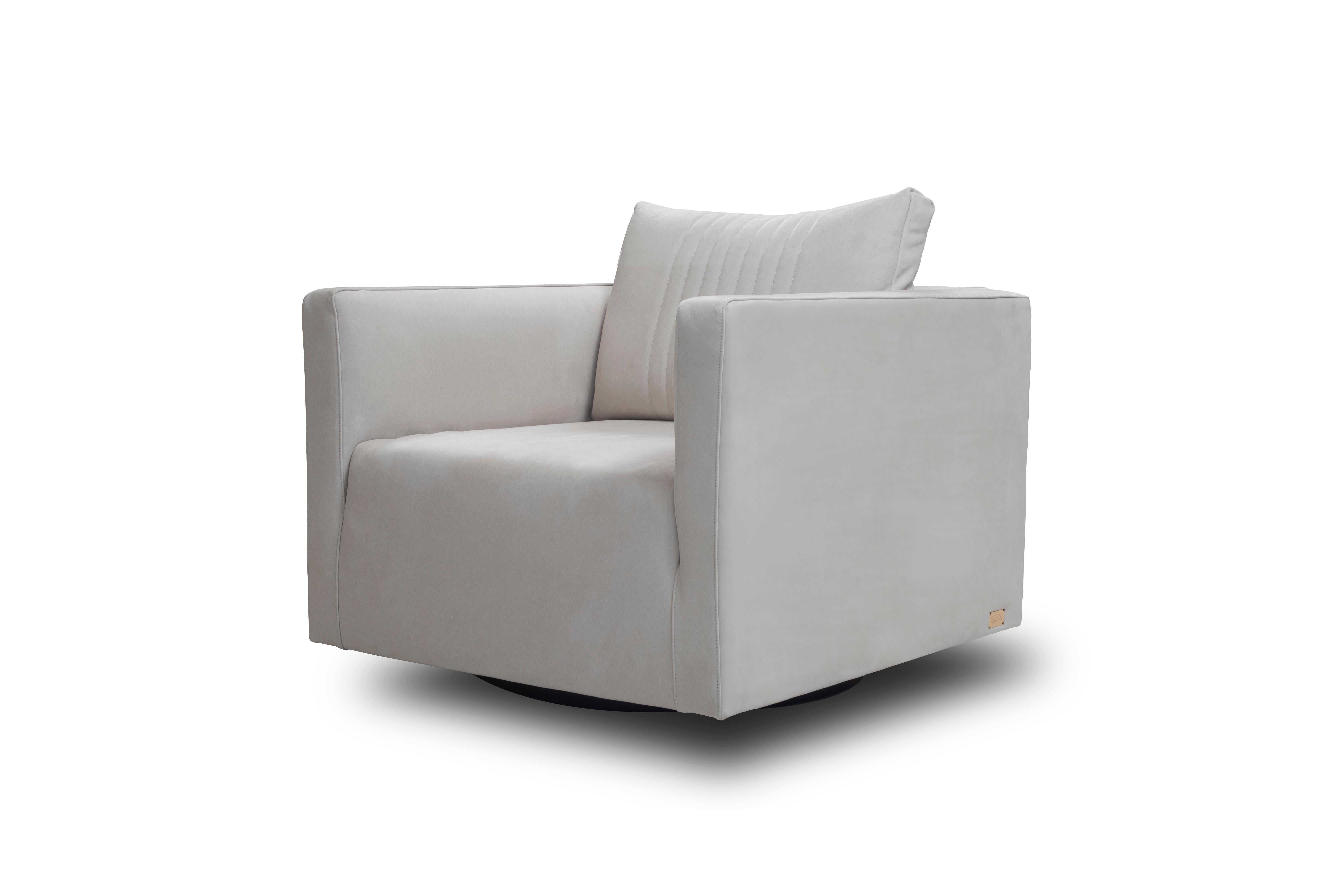The Dado Royal modern armchair elevates its cubic shape with a subtle upholstery detail culminating in a noble metal accent bar in its back. The “petit” proportions resting on a swivel base combined with a soft down-padded seat make it a flexible,