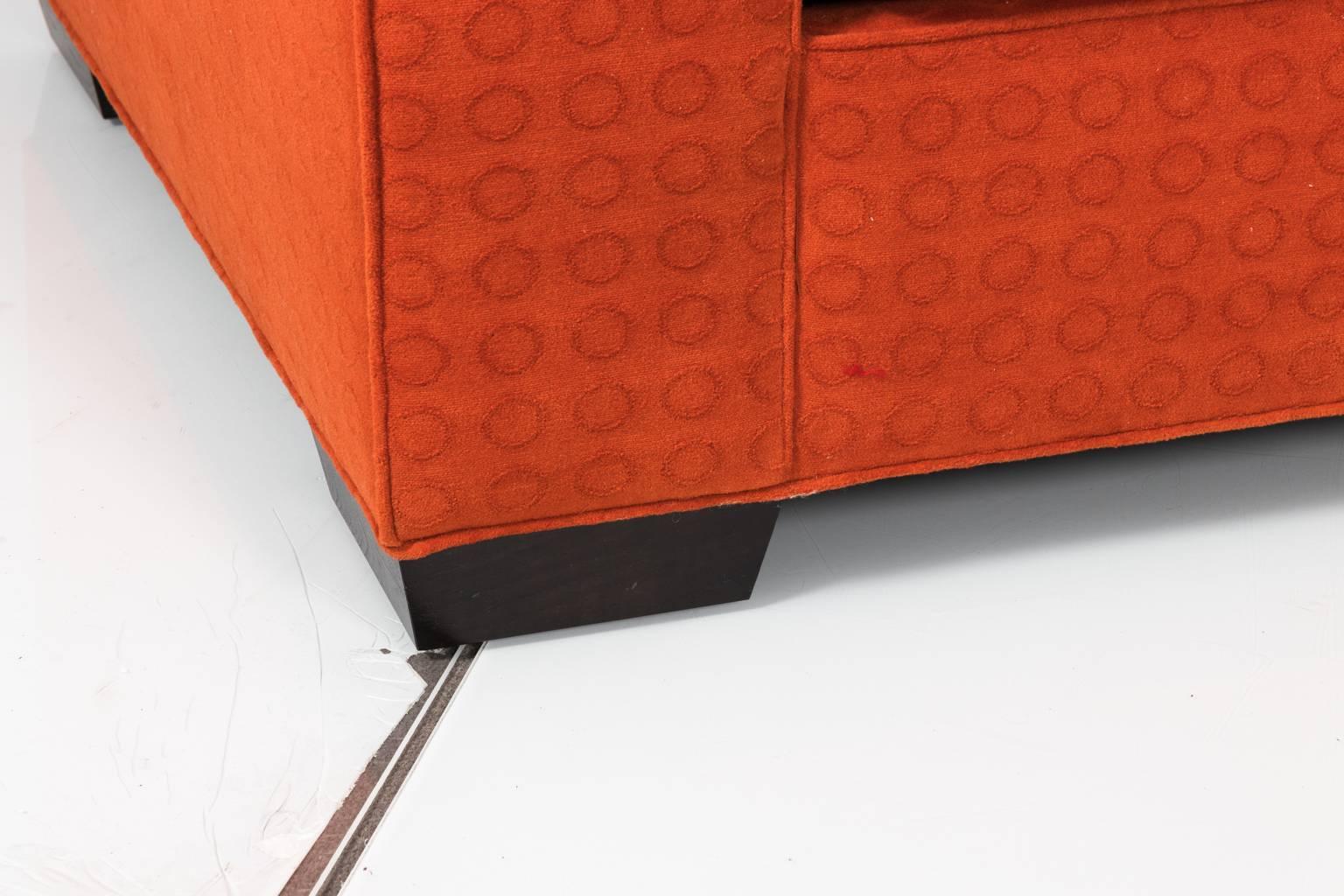 Contemporary modern upholstered sofa in a flame orange fabric.
 
