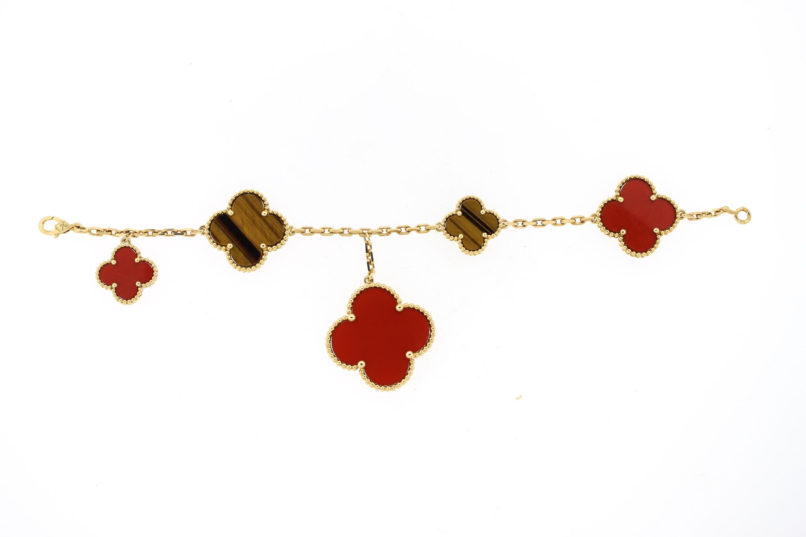 This modern 18k yellow gold carnelian and tiger's eye bracelet is part of the Lucky Alhambra collection by Van Cleef & Arpels. The bracelet is set with various sizes of the Alhambra clover. The two colors are complimentary and great for fall colors!