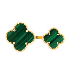 Bague moderne Van Cleef & Arpels Magic Alhambra Malachite entre les doigts