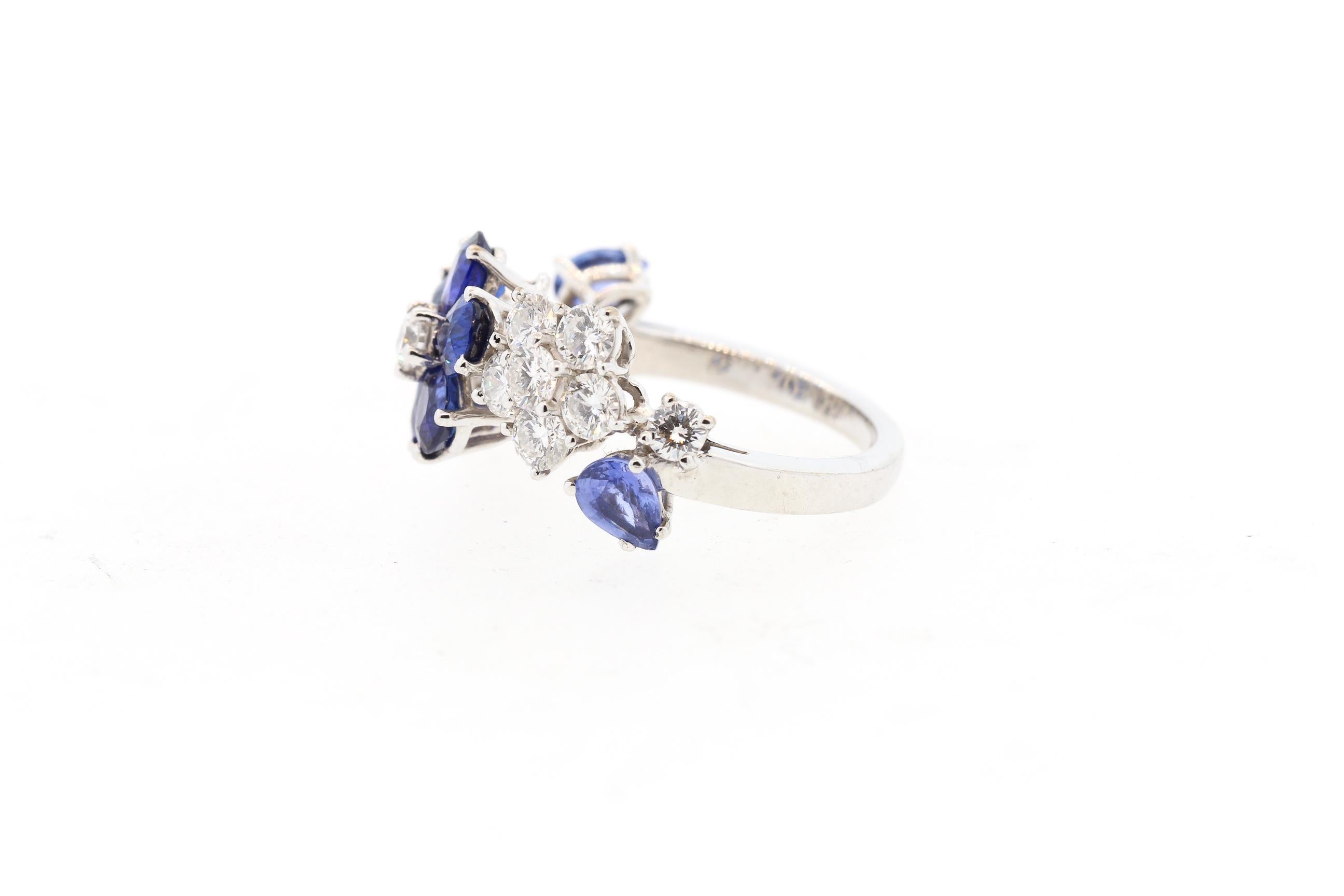 A beautiful refined sapphire and diamond flower ring made by Van Cleef & Arpels. With French hallmarks, this signed and numbered ring is from the elegant Folie des Prés High Jewelry collection by Van Cleef & Arpels. The ring is made in 18k white