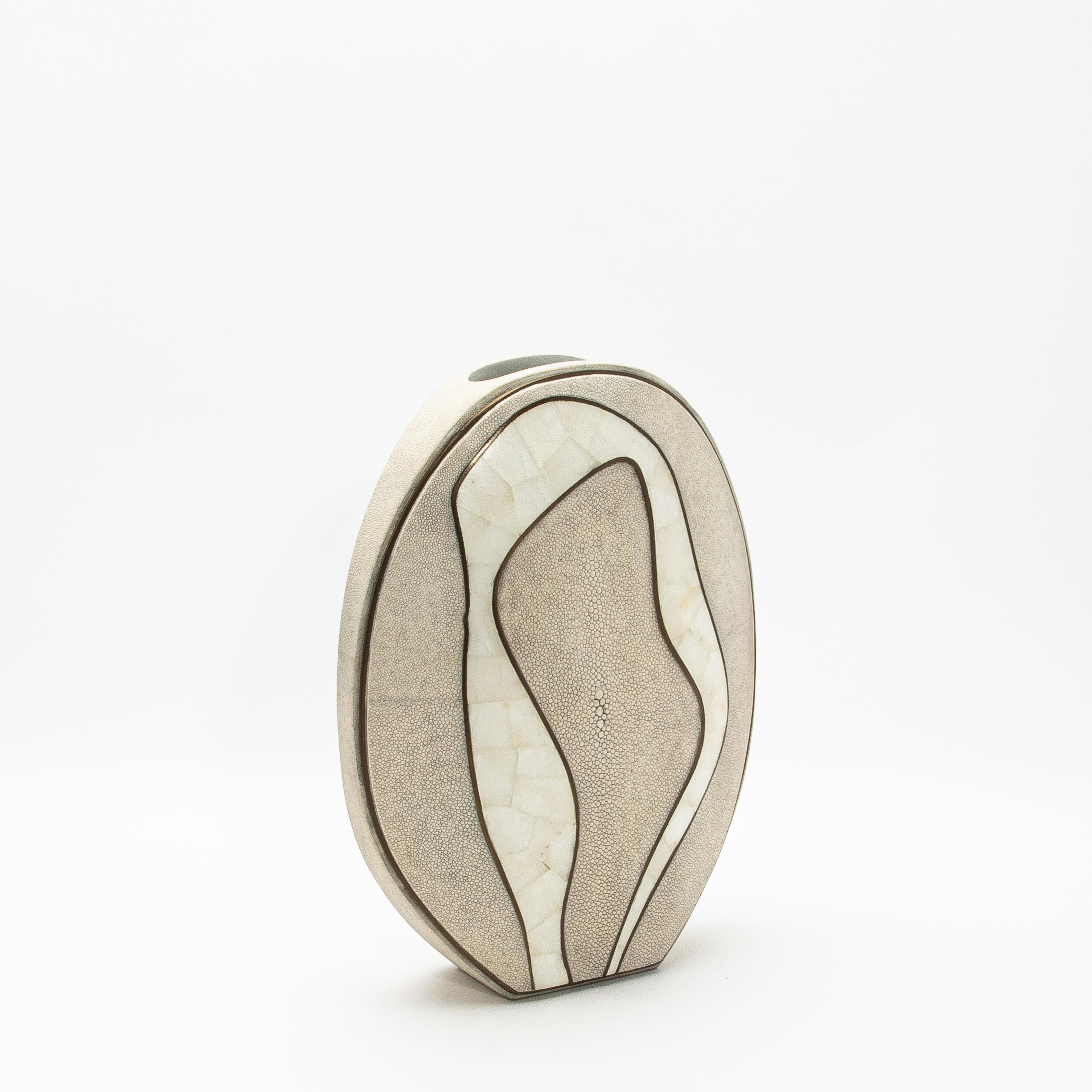 The Cocteau Vase by R&Y Augousti is an exquisite testament to modern luxury, blending natural elements with masterful craftsmanship. Its striking silhouette is adorned in refined shagreen, exuding a textured elegance, while flowing accents of white