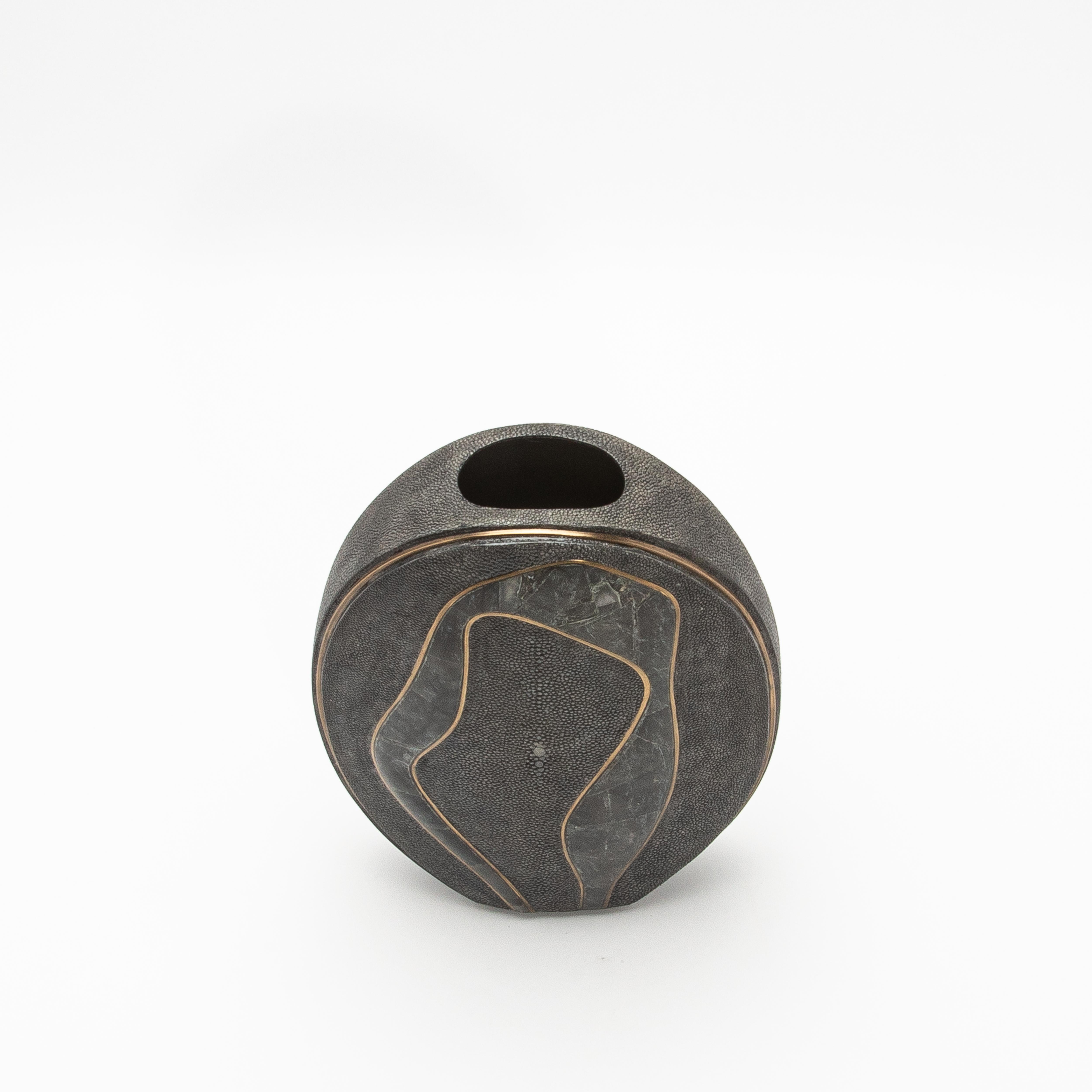 Le vase Cocteau de R&Y Augousti est un témoignage exquis du luxe moderne, alliant des éléments naturels à un savoir-faire magistral. Sa silhouette saisissante est ornée de galuchat raffiné, exhalant une élégance texturée, tandis que des accents