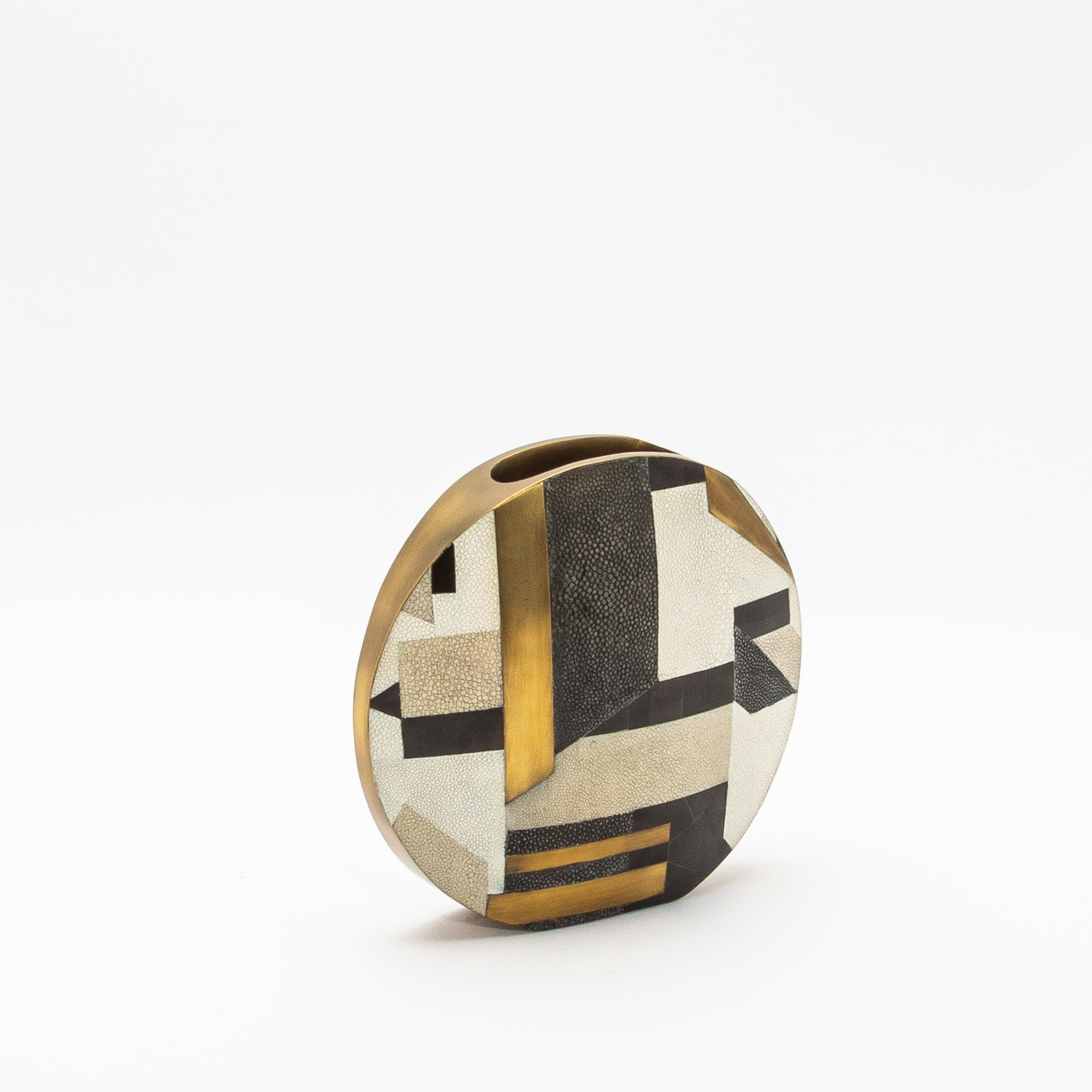 This modern vase by R&Y Augousti is a luxurious fusion of materials and craftsmanship. The intricate round form is adorned with a geometric pattern composed of shagreen, brass, quartz, and pen shell, offering a stunning interplay of textures and