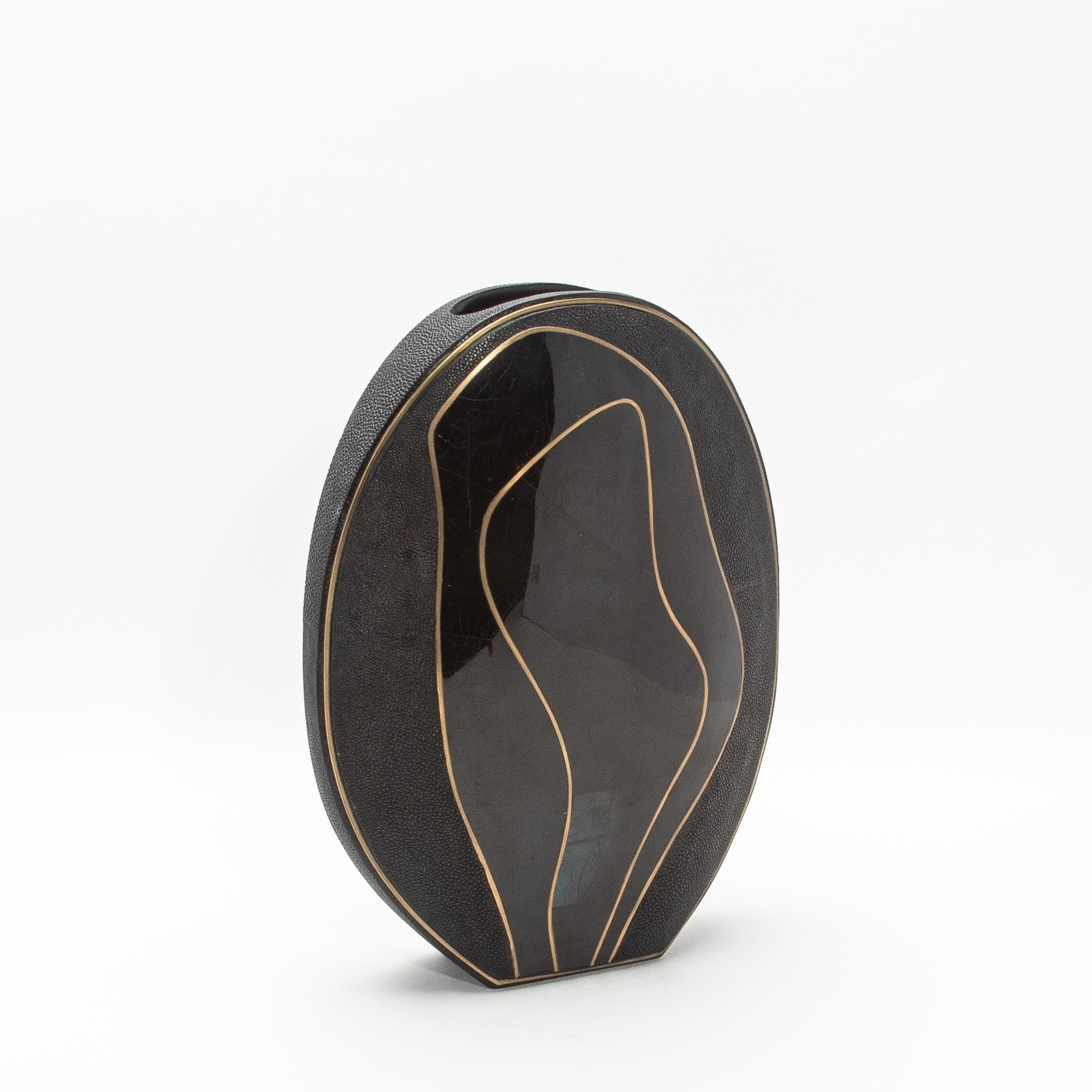 The Cocteau Oval Vase by R&Y Augousti is a masterful blend of natural elegance and sophisticated craftsmanship. This large-sized vase is meticulously handcrafted from luxurious shagreen, lending a subtle textured finish that enhances its refined
