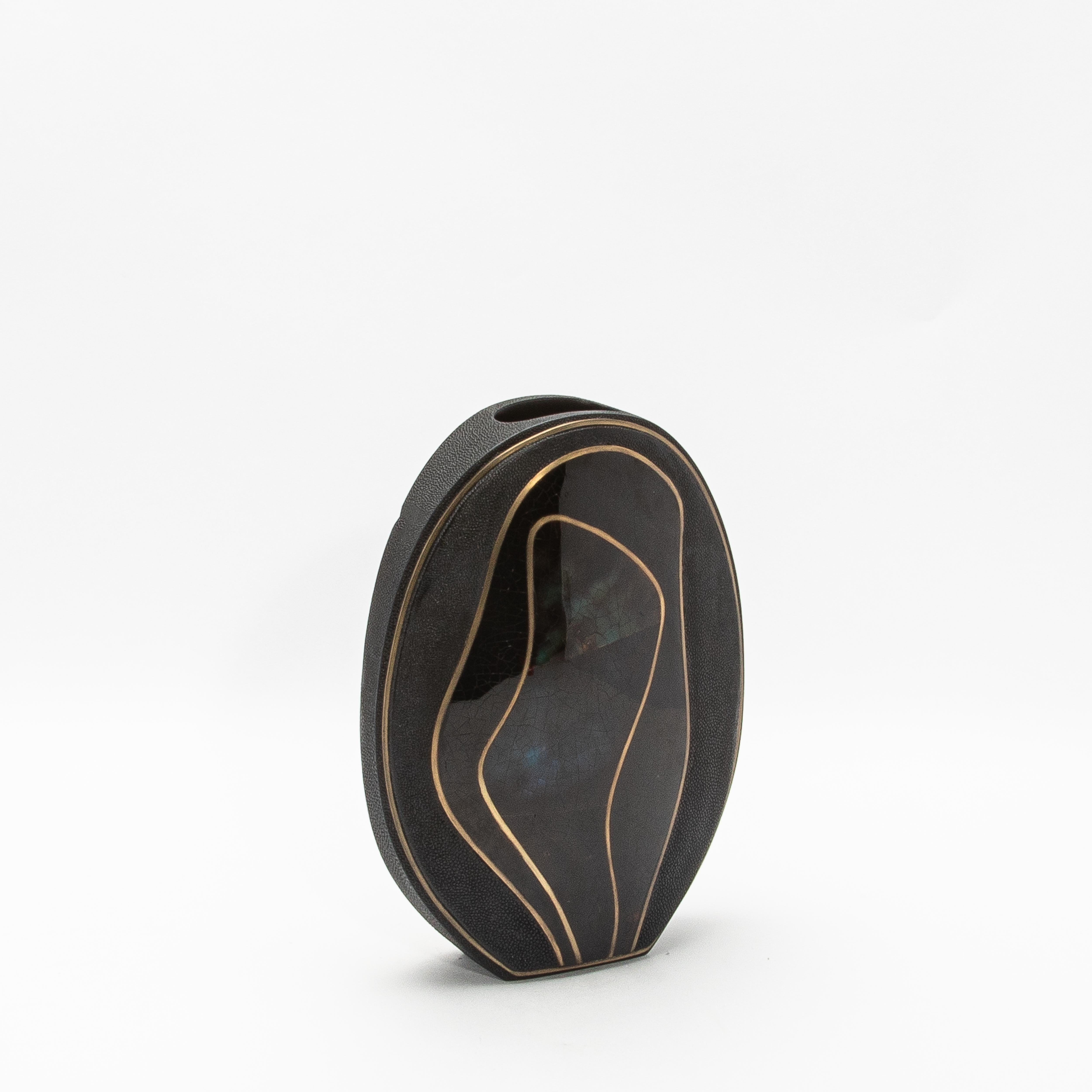 The Cocteau Oval Vase by R&Y Augousti is a masterful blend of natural elegance and sophisticated craftsmanship. This large-sized vase is meticulously handcrafted from luxurious shagreen, lending a subtle textured finish that enhances its refined
