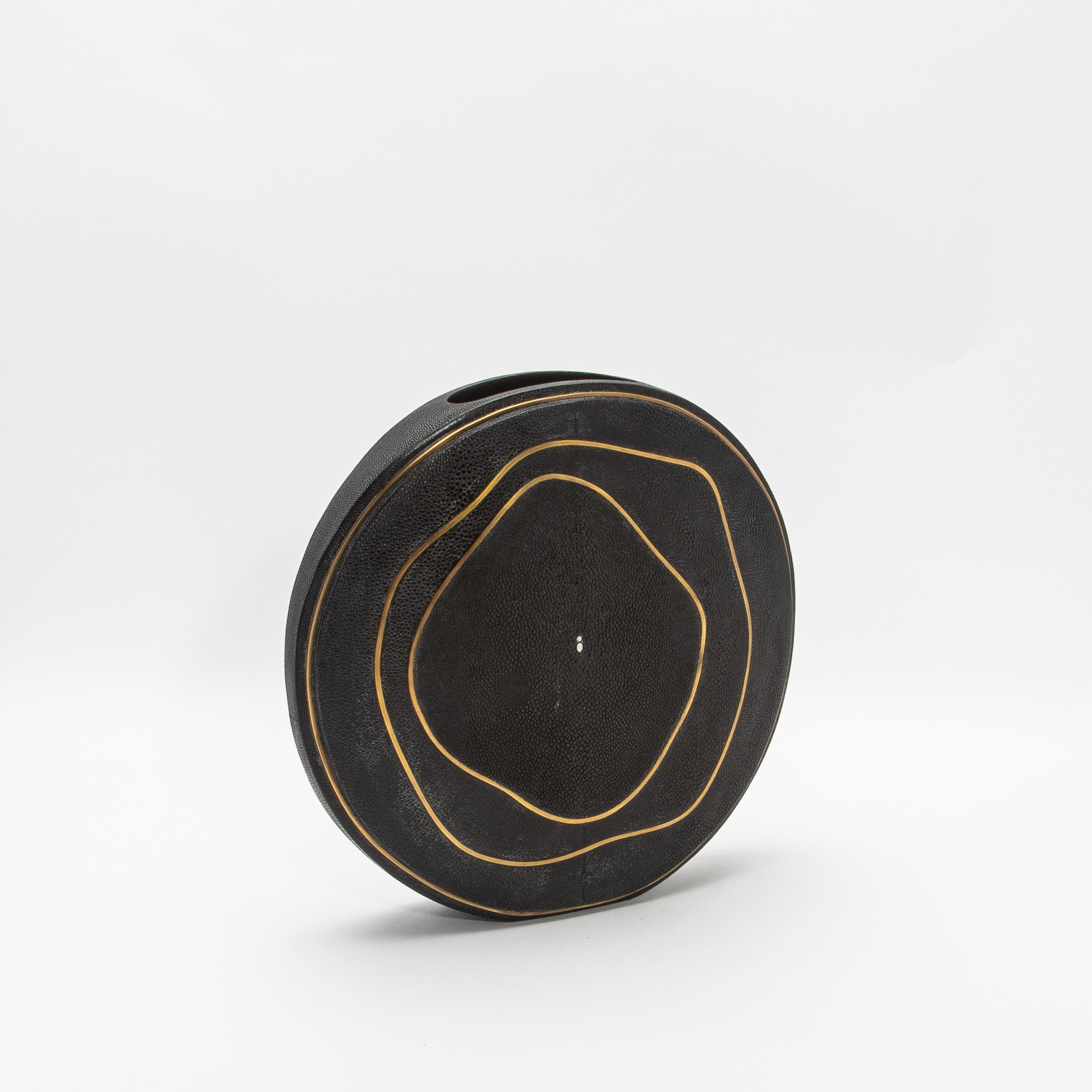 This exquisite vase by R&Y Augousti captures the essence of artisanal craftsmanship with its luxurious shagreen surface, complemented by the elegance of hand-finished brass detailing. The round form offers a sculptural, modern silhouette, while the