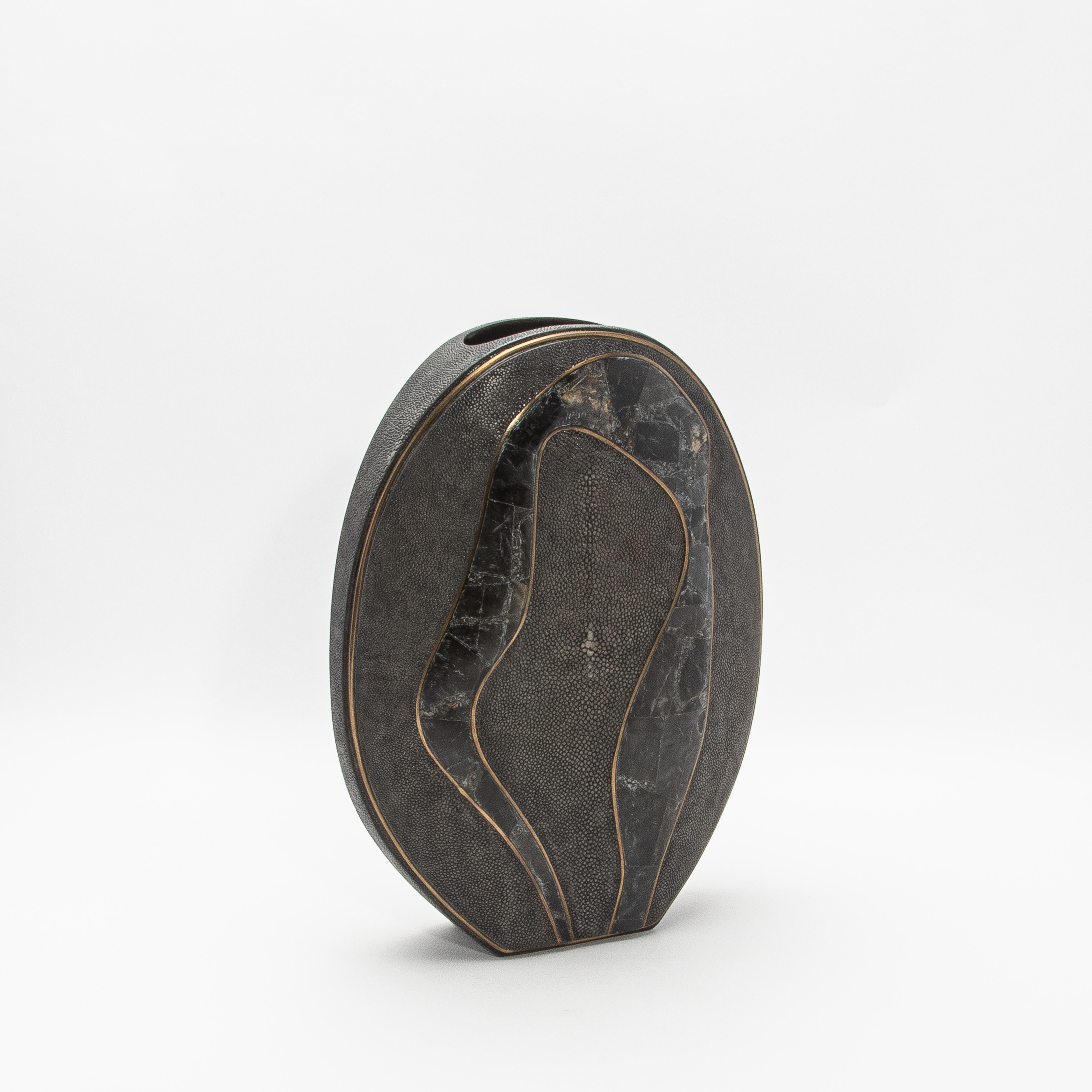 The Cocteau Vase by R&Y Augousti is an exquisite testament to modern luxury, blending natural elements with masterful craftsmanship. Its striking silhouette is adorned in refined shagreen, exuding a textured elegance, while flowing accents of black