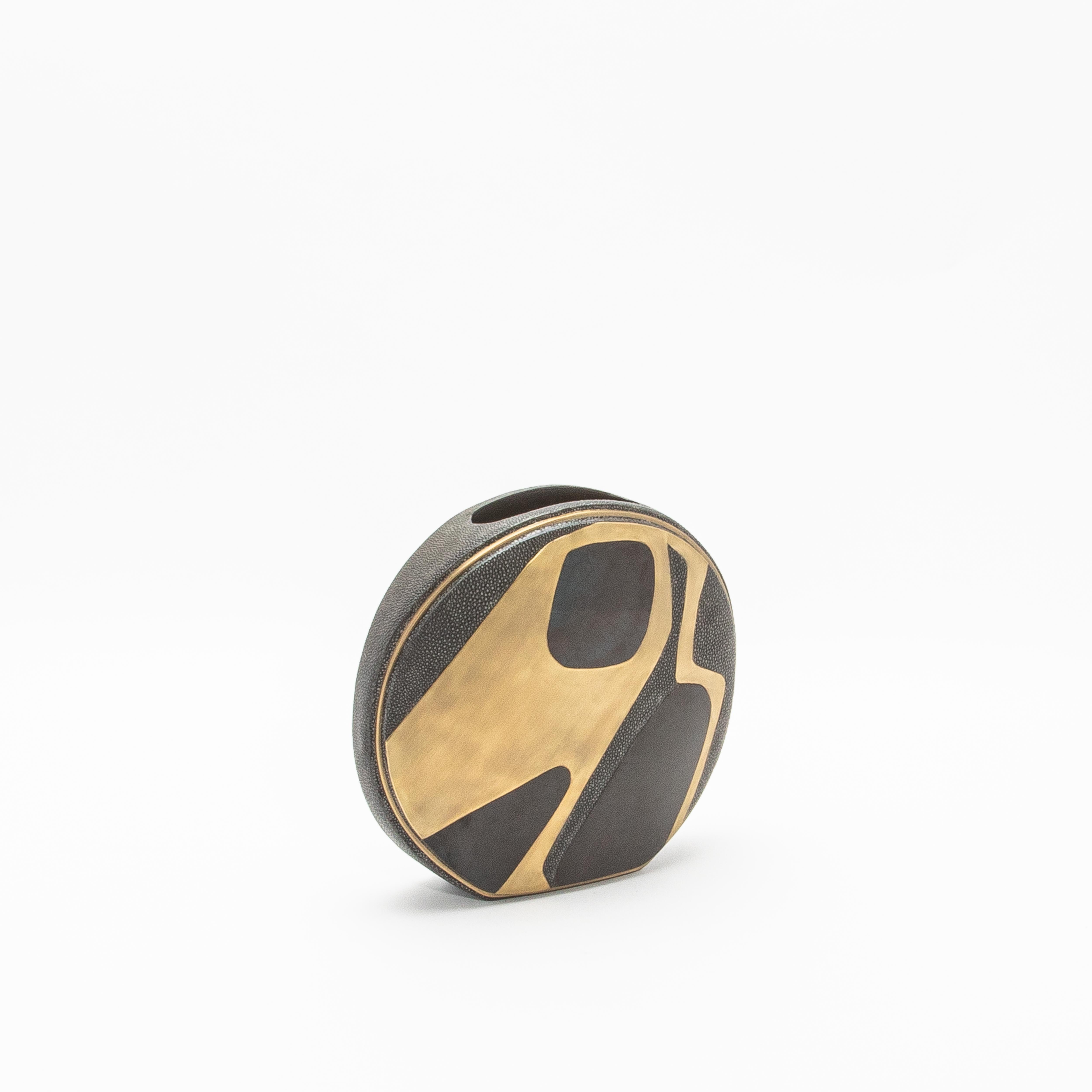 Le vase circulaire Cosmos Dark de R&Y Augousti est une incarnation étonnante de l'art raffiné et des matériaux luxueux. Fabriqué en galuchat, ce vase présente une texture élégante, à la fois intemporelle et tactile. Ses incrustations de laiton