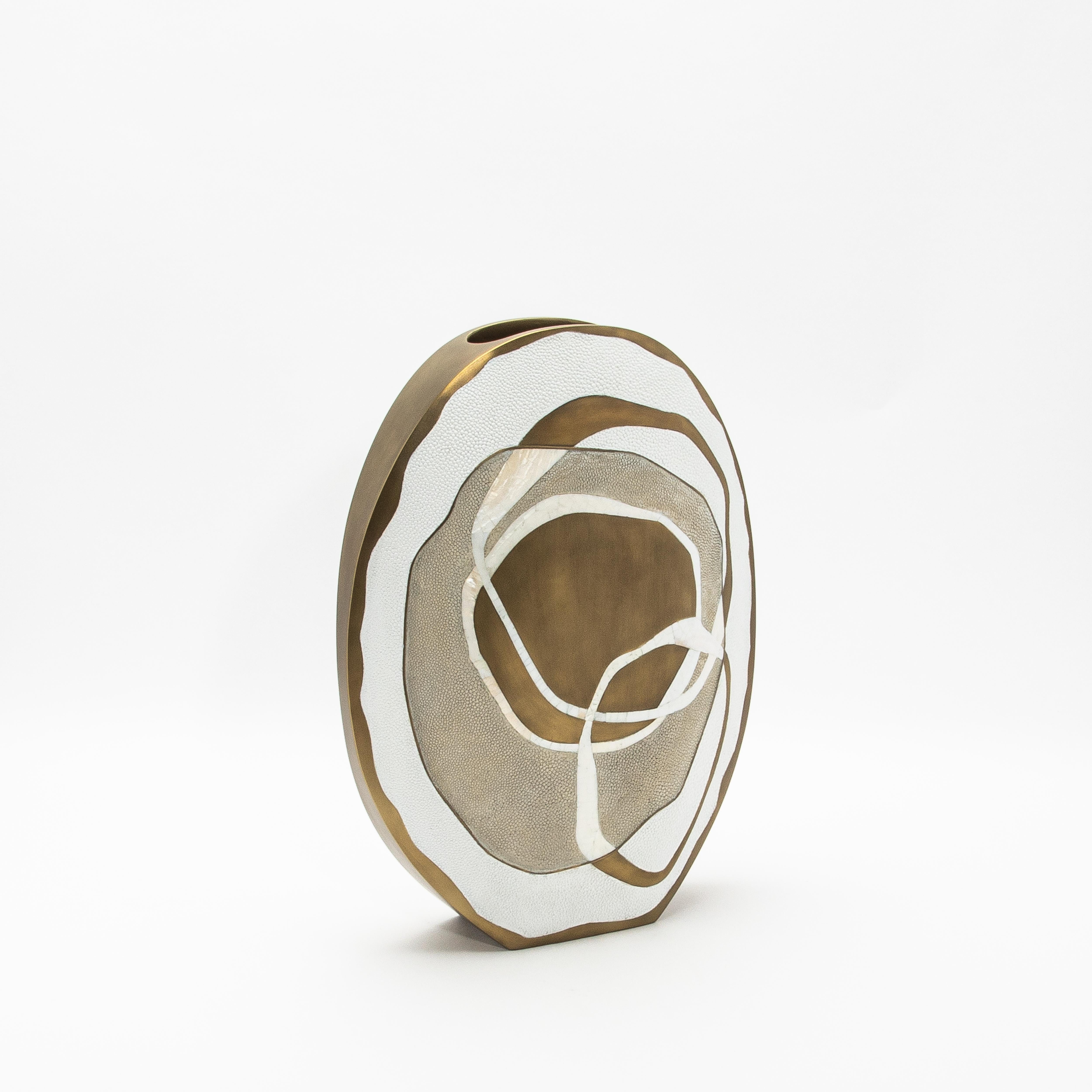The Rose Vase by R&Y Augousti is a stunning creation that embodies contemporary luxury through its masterful combination of exquisite materials. Handcrafted from rich shagreen, polished brass, and intricate mother of pearl, this vase is a testament
