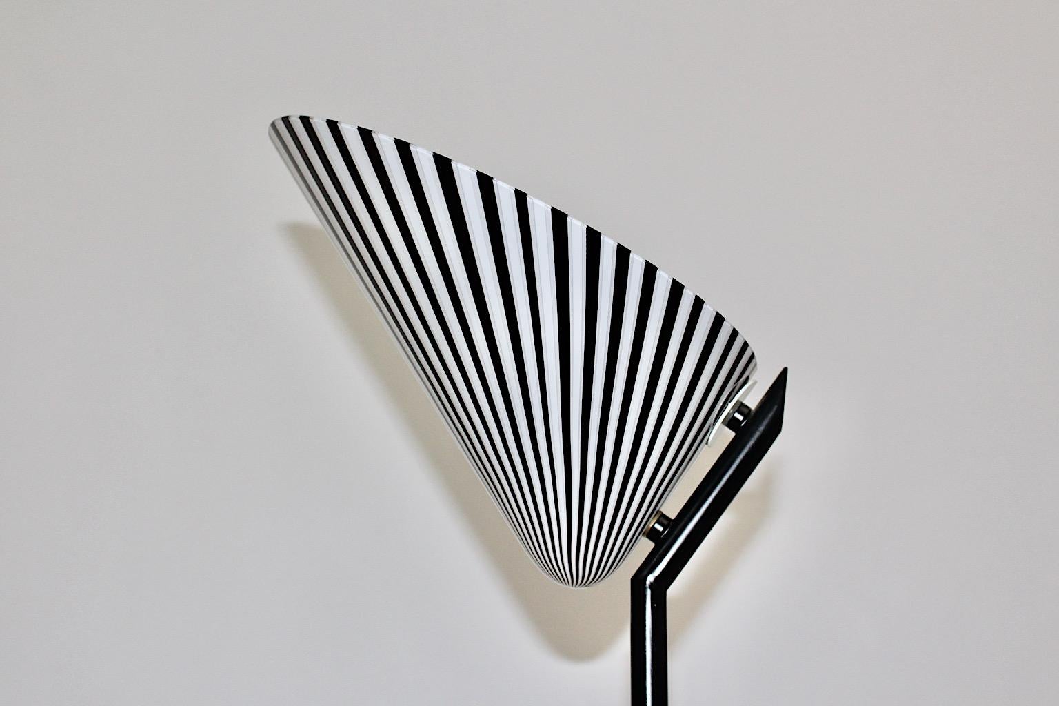 Modern black and white glass metal floor lamp or uplighter designed 1980s, Italy. 
A gorgeous and timeless floor lamp with an outstanding black and white striped
shell - shaped lamp shade from glass and a black lacquered metal tube base. 
On/off