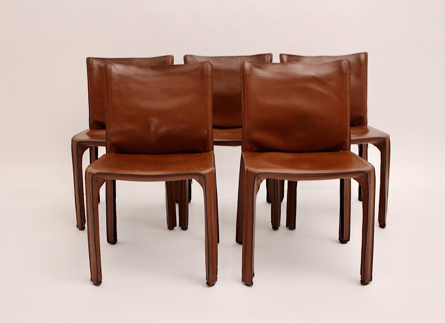 Modern set of 5 vintage Cab 412 dining room chairs or chairs designed by Mario Bellini for Cassina 1976 Italy from cognac brown ( aged and patinated china red sattle ) leather.
Thick leather covers a metal skeleton and features zipped feet.
Stable,