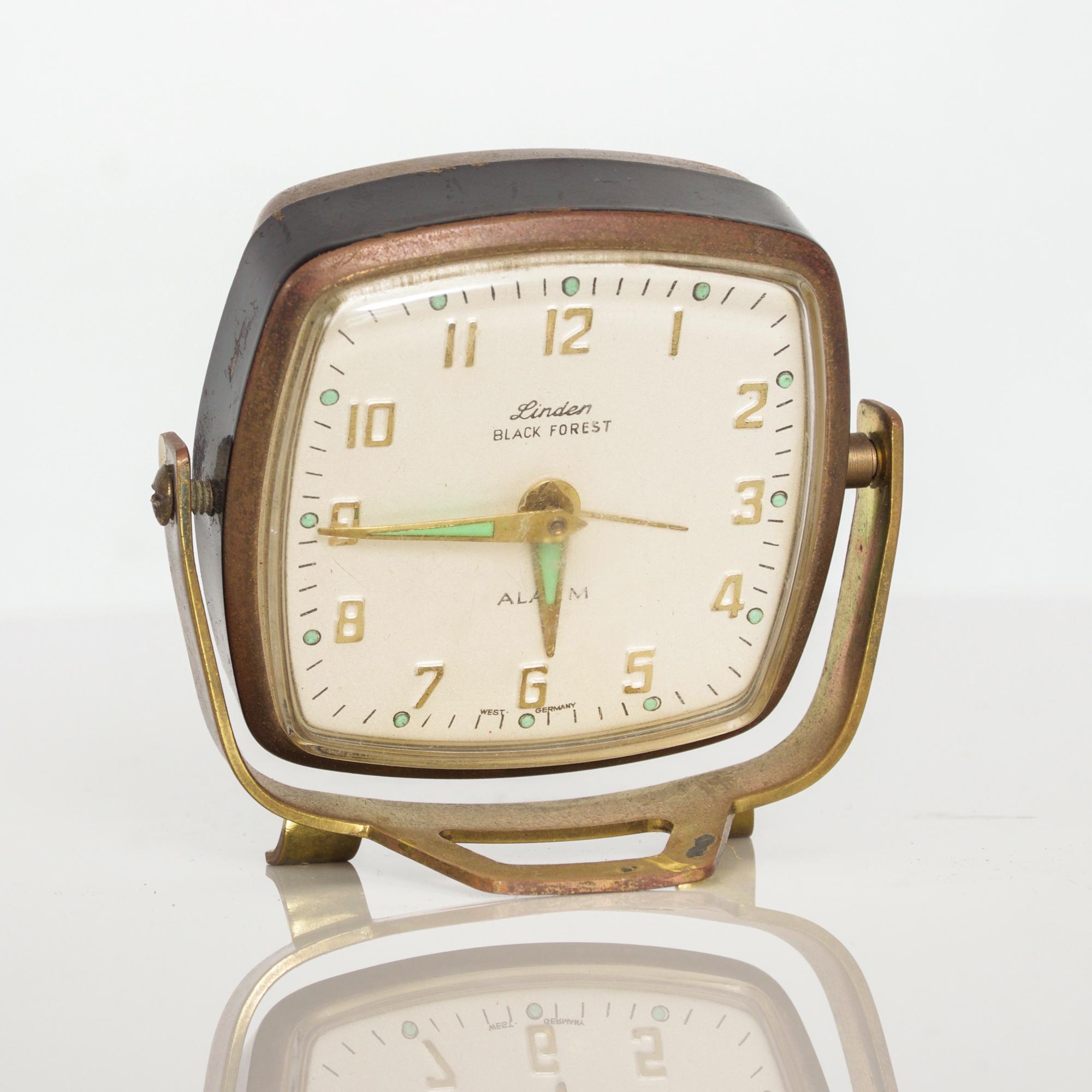 Mid-Century Modern charming Vintage Linden Alarm Clock wind up in aged golden Brass with green accents made Black Forest West Germany. 
Fabulous flexible rotating design and footed frame.
Measures: 3