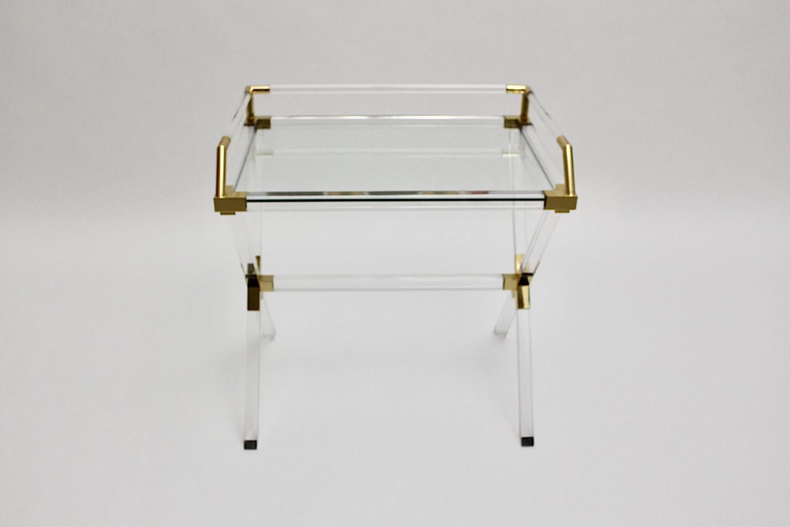 Modern vintage serving table or  side table or Lady´s desk from lucite in clear and gold color Italy, 1970s.
A charming side table or small desk from lucite with a lucite body and golden colored corners and details. While the x crossed feet provides