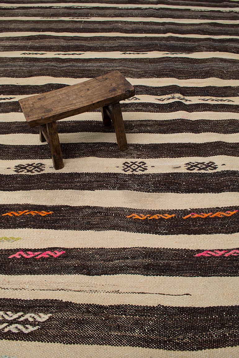 This vintage Kilim is simple in design with its natural color palette and hand-embroidered tribal motifs. The horizontal lines and aged patina provide a rustic raw beauty. Just unique and authentic. The most remarkable attribute about these types of