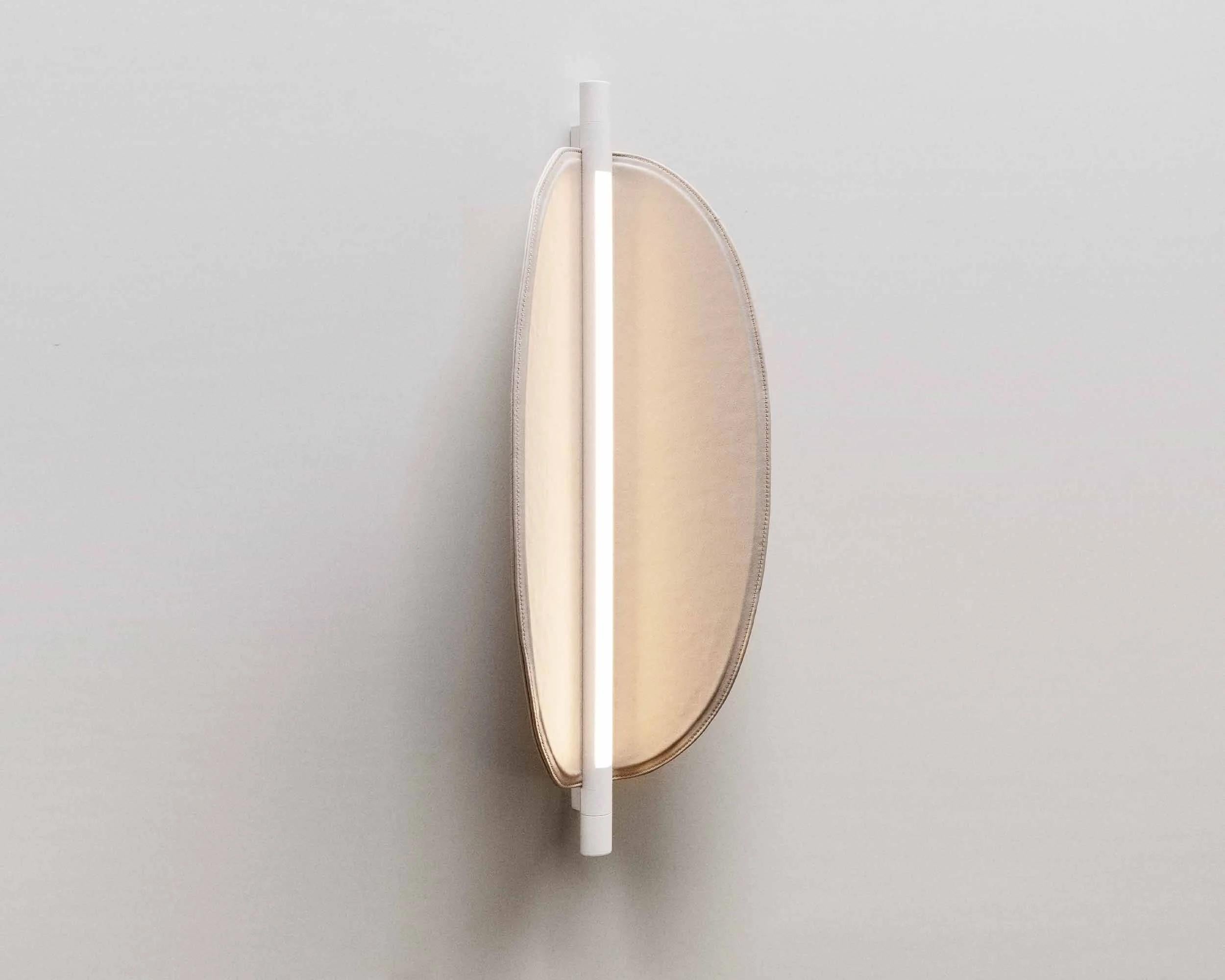 Thula 562.41 by Frederica Biasi x Tooy
Wall lamp
Compliant with USA electric system

Model shown: 
- hardware Beige 
- details Beige
- shade Canaletto walnut

Materials: aluminum, metal, leather, wood

The Thula wall lamps are based on a simple and