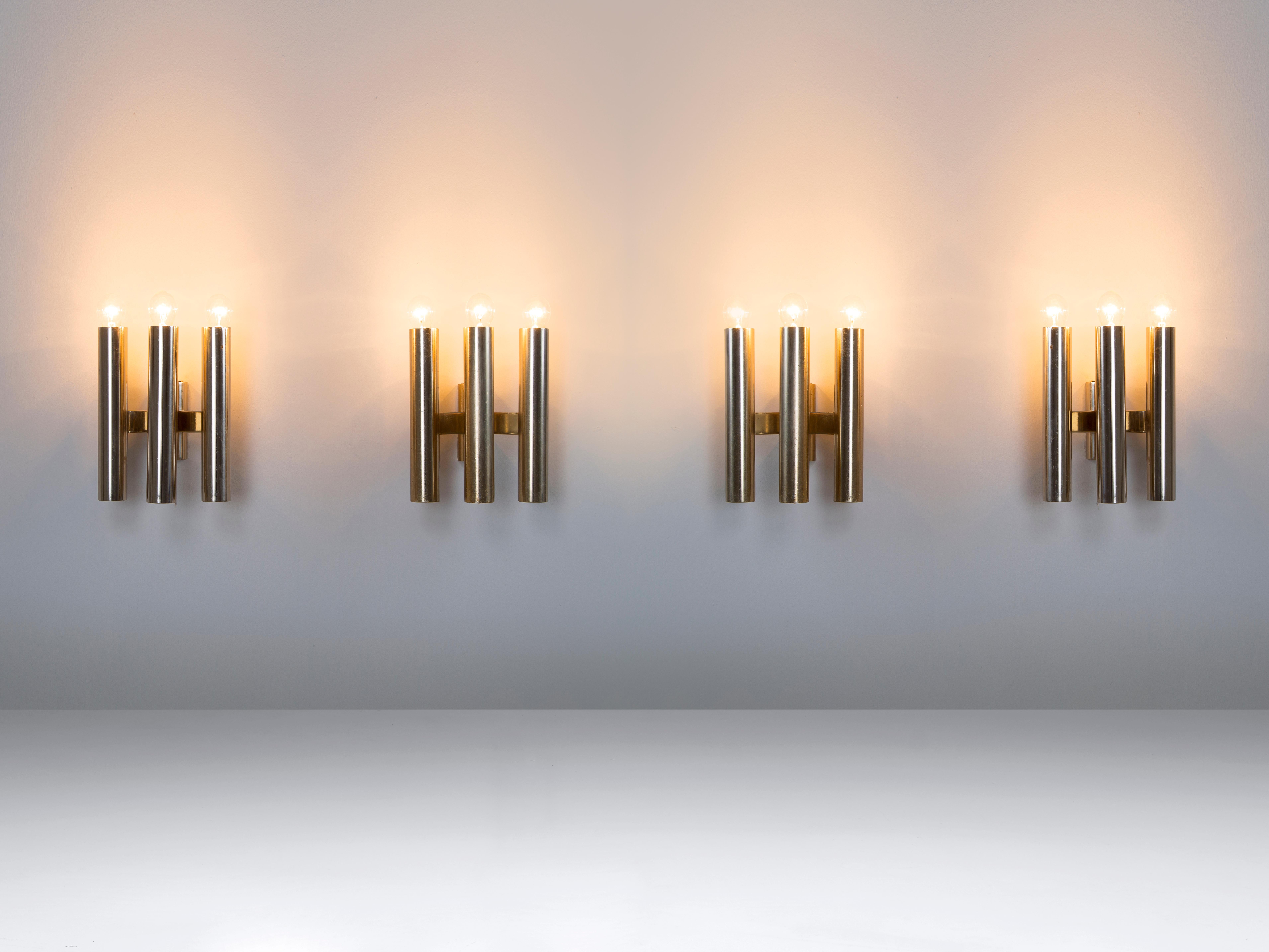 Wall lights, chromed metal, Europe, 1970s.

Set of wall lights. Each light consist of three cylindrical chrome candle holder inspired tubes which are held by a chrome frame. The alignment of these three lights are formed in a triangle composition,