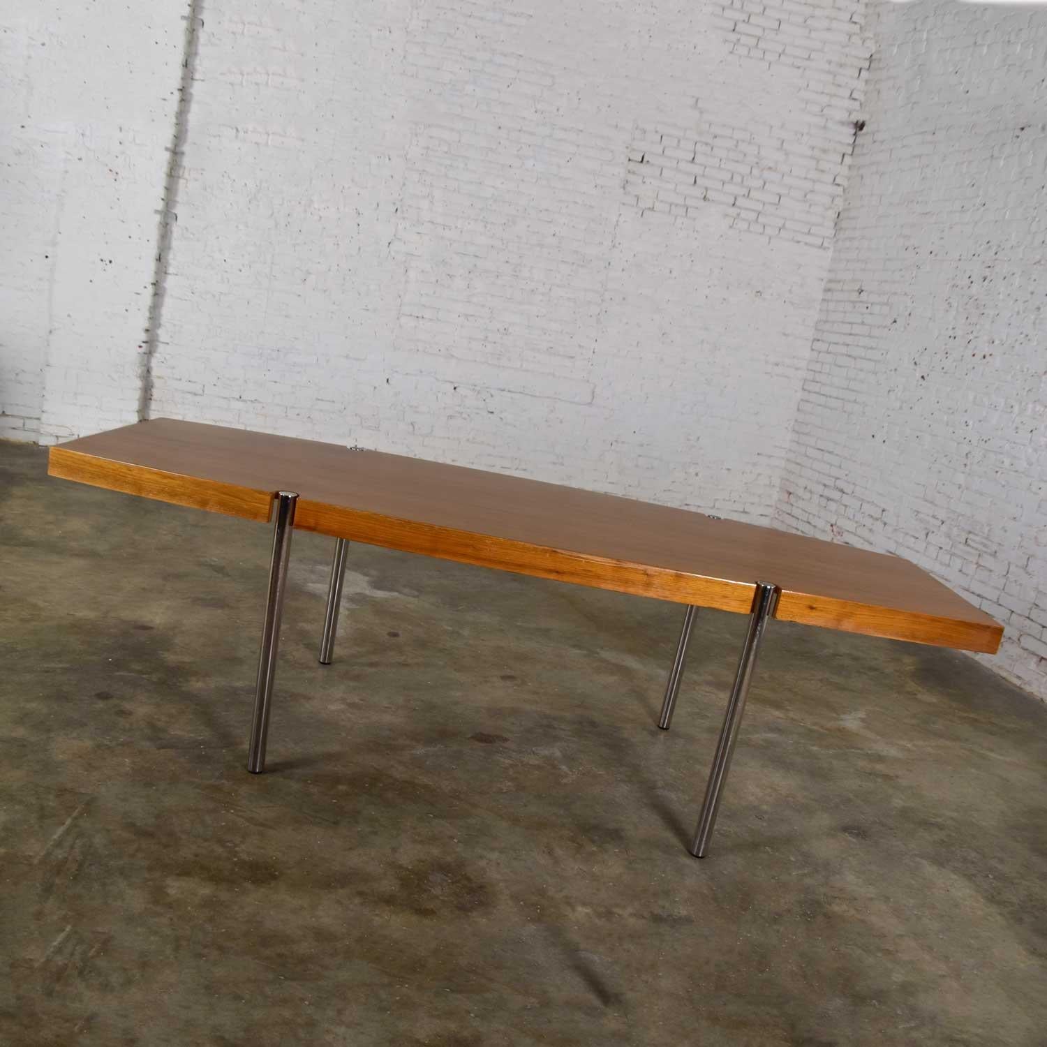 Fabulous modern boat shaped dining table or conference table by Jens Risom for Howe Furniture. Comprised of walnut veneer and chrome cylinder legs. Gorgeous age and use appropriate condition with a couple of minor dings in work surface and a small