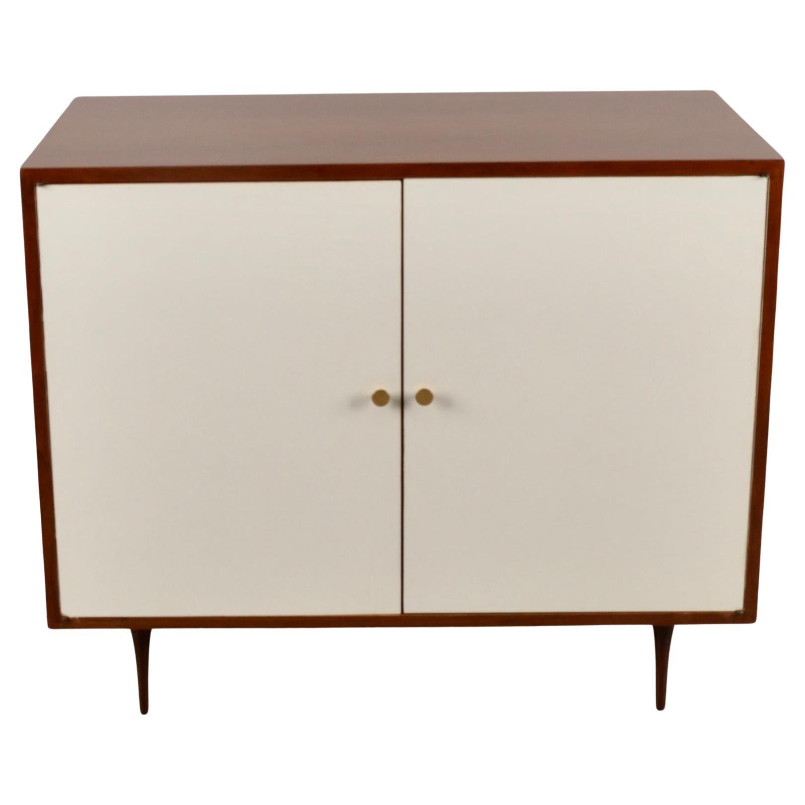 Simple cabinet in walnut with laminate veneered doors. Great size. Original brass pulls. And check out the spikes legs. So fab! Beautifully refinished with matte lacquer. Very fine condition.