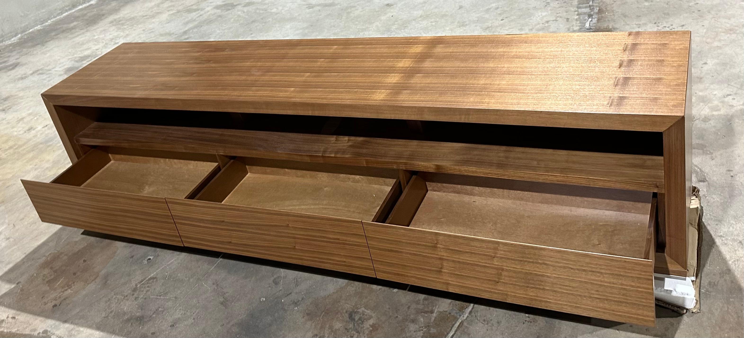 Plataforma de entretenimiento para TV  diseñado por Greg Sheres. Ahora en stock.  Esta es nuestra plataforma de televisión clásica.  Un diseño largo y elegante que contiene 3 compartimentos para equipos audiovisuales y 3 cajones para guardar DVD y