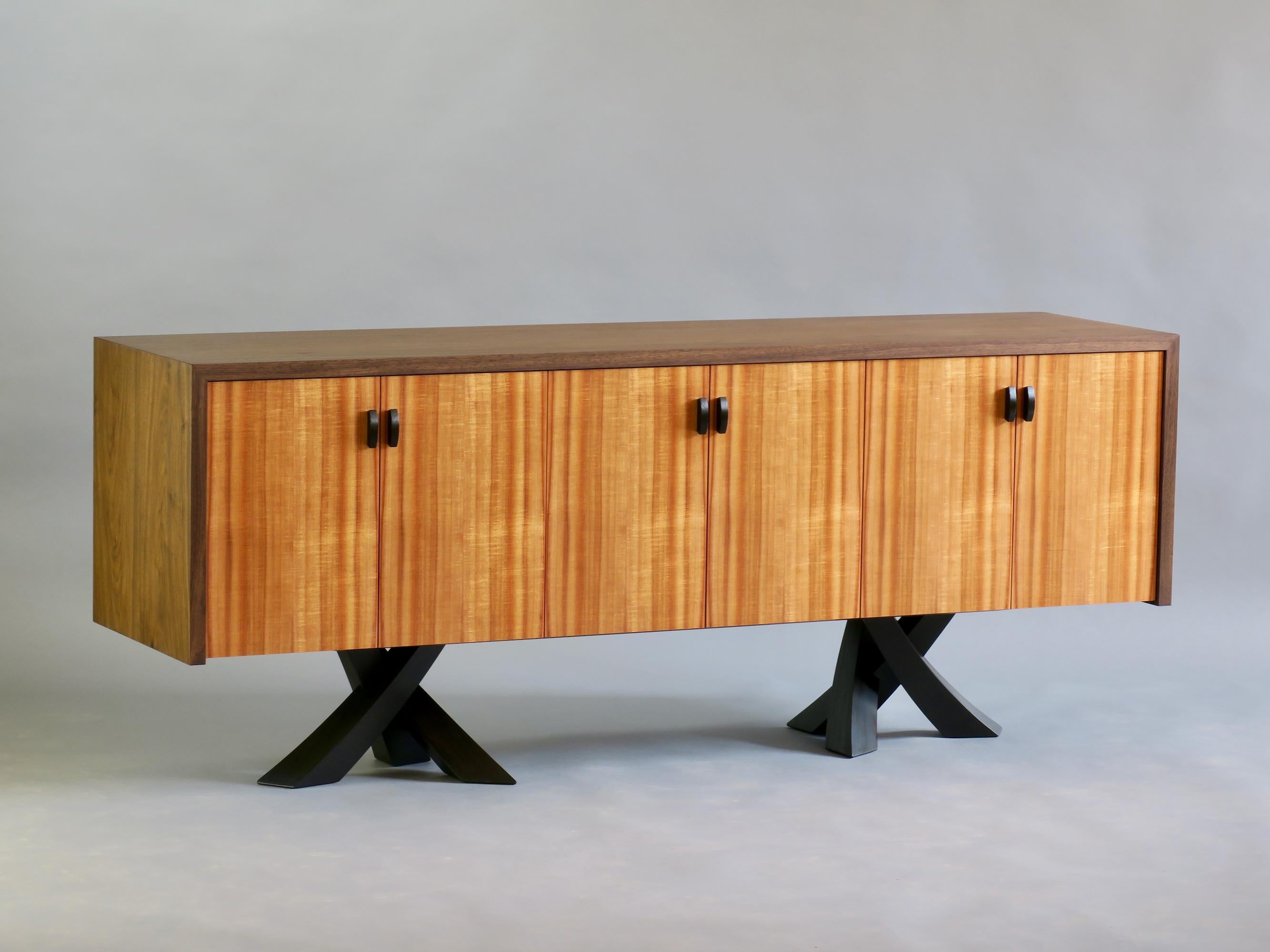 The Laguna credenza is a study in contrast and form. The rectilinear cabinet balances elegantly on six energetic legs full of movement. The six doors feature the prominent rift sawn grain of rare iridescent Hawaiian koa which is framed by the solid