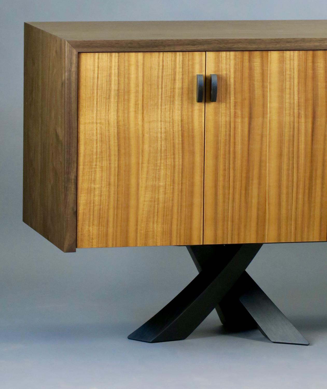 The Laguna credenza is a study in contrast and form. The rectilinear cabinet balances elegantly on six energetic legs full of movement. The six doors feature the prominent rift sawn grain of rare iridescent Hawaiian koa which is framed by the solid