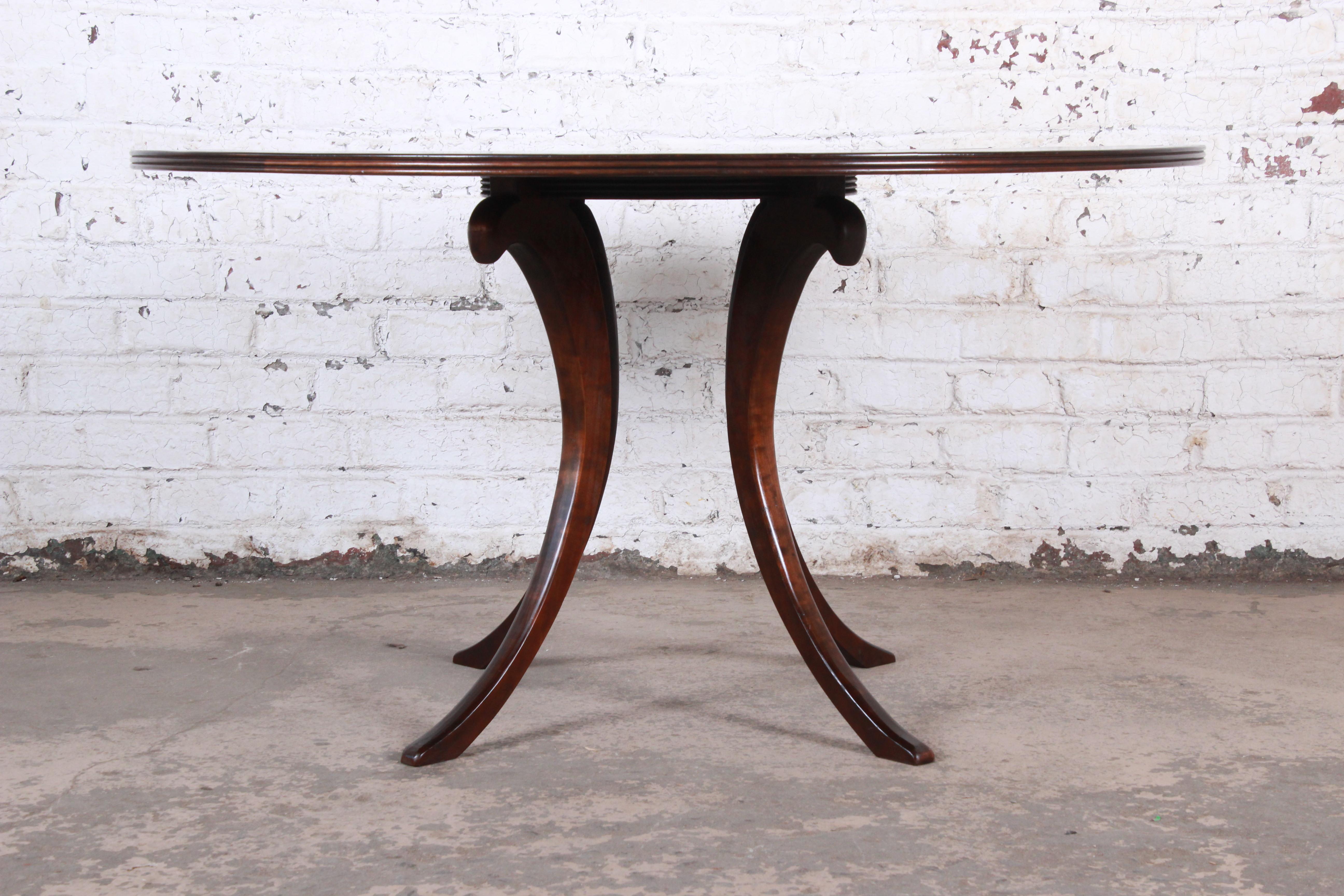 A gorgeous modern walnut saber leg dining table with inlaid starburst parquetry top

Late 20th century

Measures: 54.75