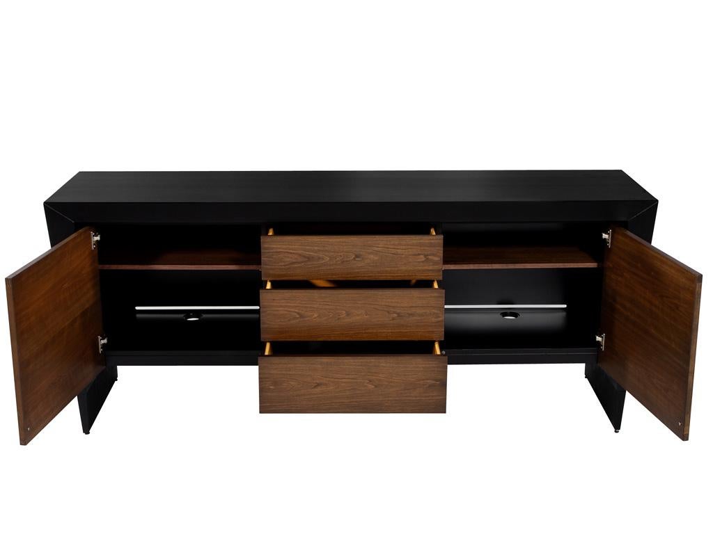 Elevate your living space with the exquisite modern walnut sideboard buffet cabinet from Baker Furniture. This striking piece seamlessly blends modern design with functionality, showcasing a detailed walnut front that exudes warmth and