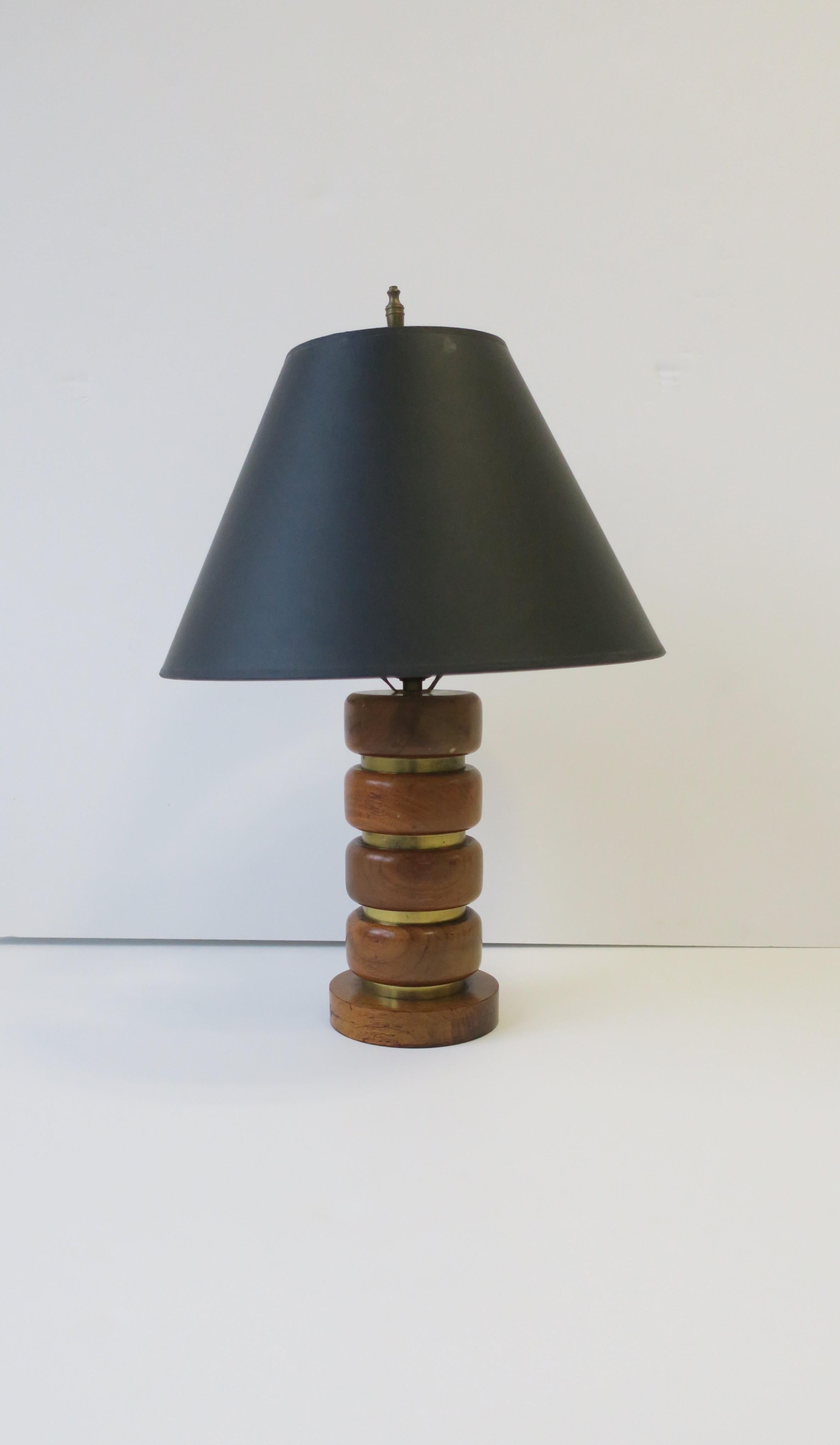 A Midcentury Modern walnut wood and brass desk or table lamp, circa mid-20th century. Lamp is turned wood with soft edges and indents of horizontal brass bands. This lamp would make a great desk or table lamp; in a convenient size measuring: 

Lamp