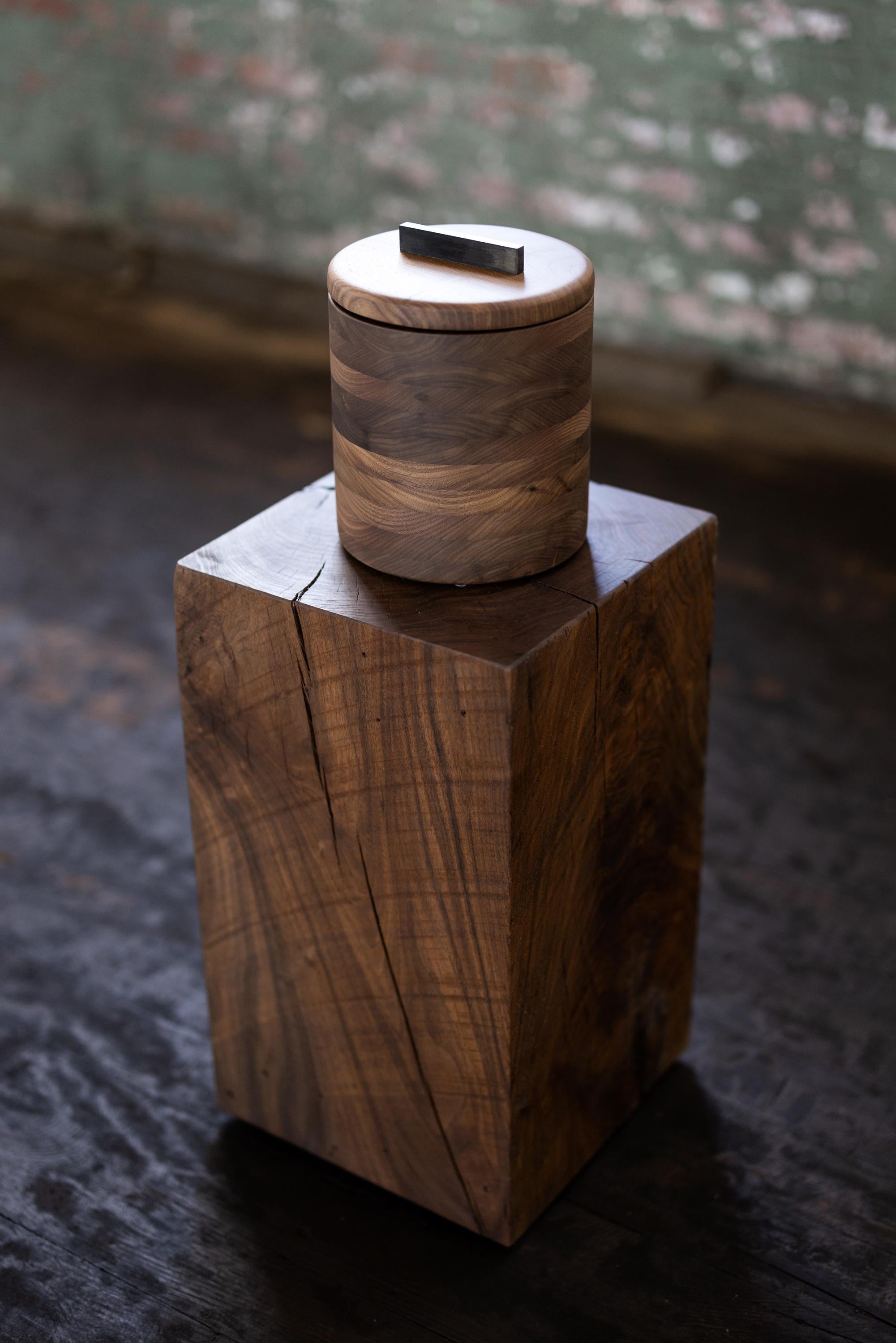 This Modern Walnut Wood and Steel Ice Bucket is crafted with black walnut from Birmingham's urban forest. The Mid-Century modern design displays stripes of natural grain and a range of colors to create a unique geometric accent for the bar. Store
