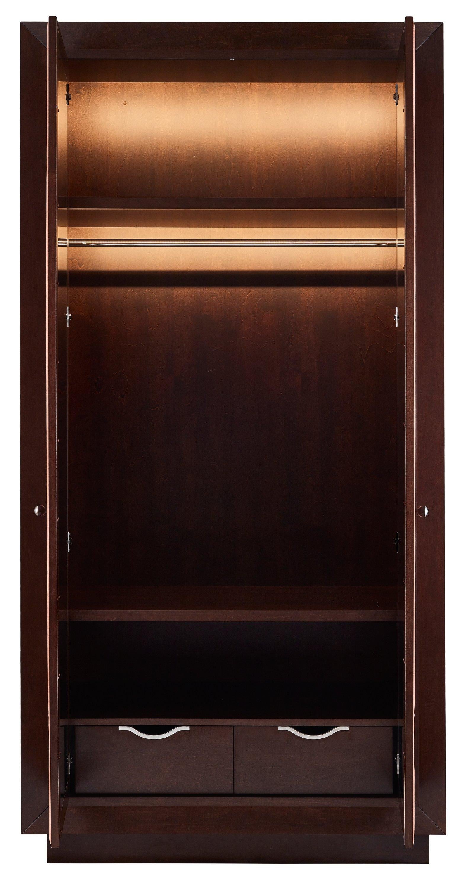 The high wardrobe is finished in fine tinted sycamore veneer and salmon Alcantara on door panels. The panels are decorated with the pattern of chrome-plated studs. The fern-like poetic pattern brings here the magic of enchanted forests.
The