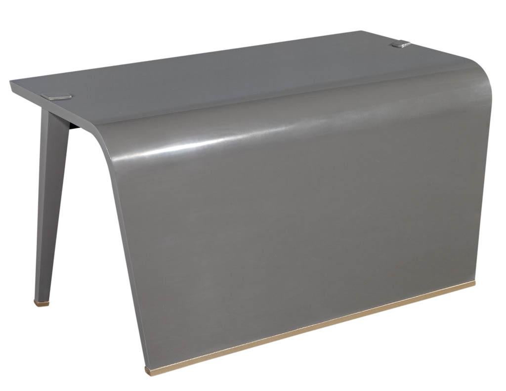 Modern waterfall desk in custom grey hand polished finish. Beautiful modern minimalist design with sculpted waterfall accent. Hand polished in a grey lacquer finish with hand painted brass color trim details. Price includes complimentary curb side