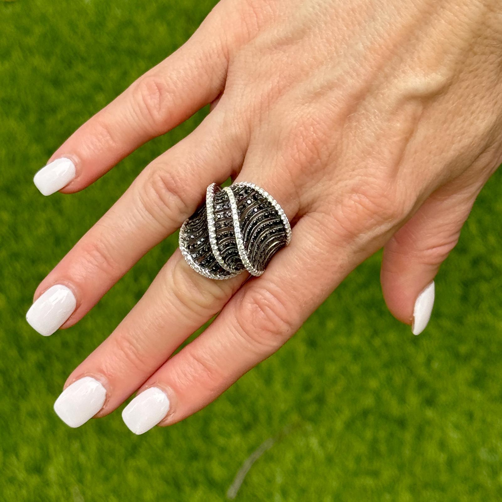 Dieser auffällige Ring aus 18 Karat Weißgold mit aufgefächerten Diamanten zeigt einen kühnen Kontrast aus funkelnden weißen und geheimnisvollen schwarzen Diamanten in einem auffälligen Design. Mit 114 runden weißen Diamanten im Brillantschliff von