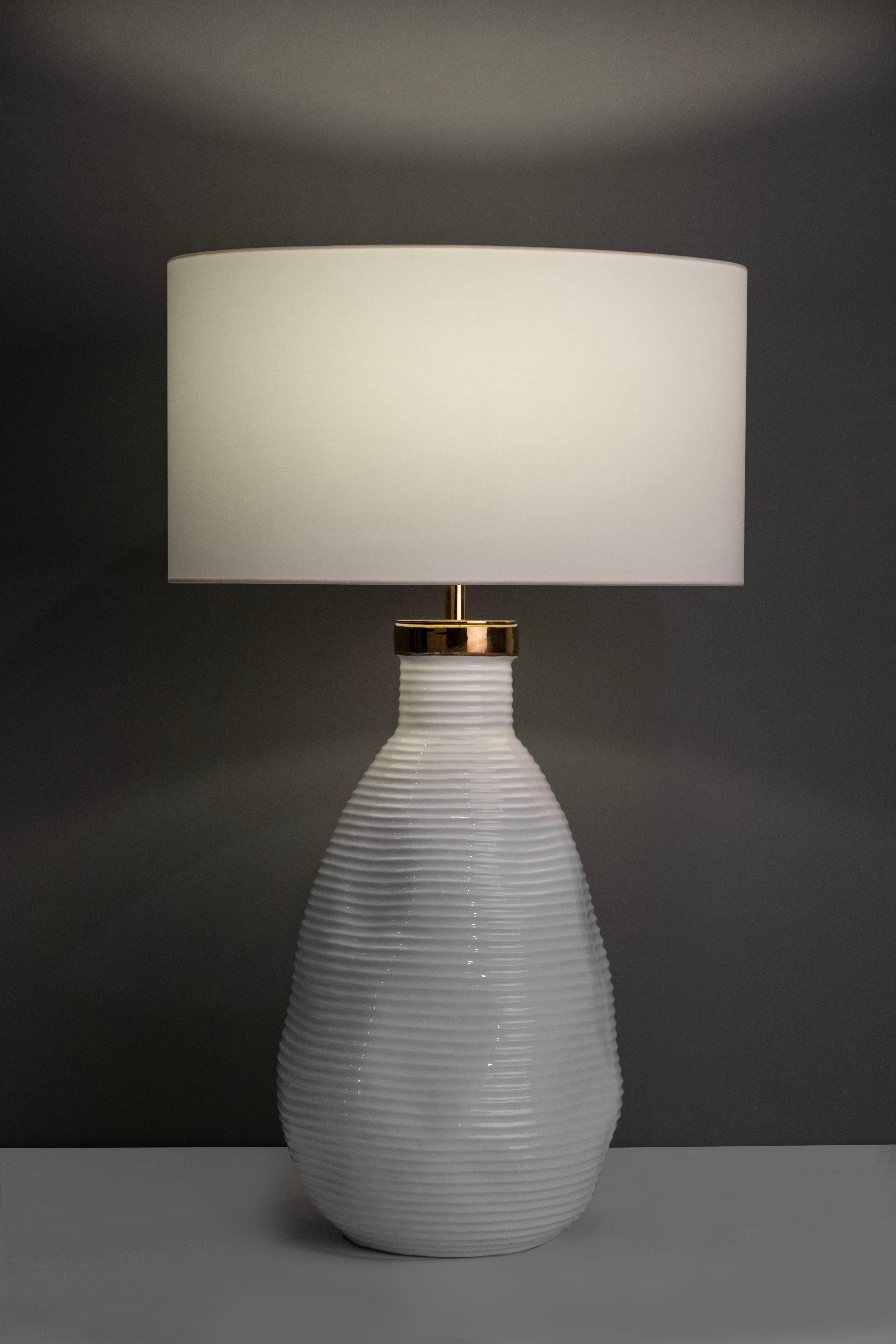 Candeias table lamp, Modern Collection, Handcrafted in Portugal - Europe by GF Modern.

The Candeias table lamp creates a subliminal ambience for extraordinary living. The base in white glazed ceramic with a gold detail on top harmonizes seamlessly