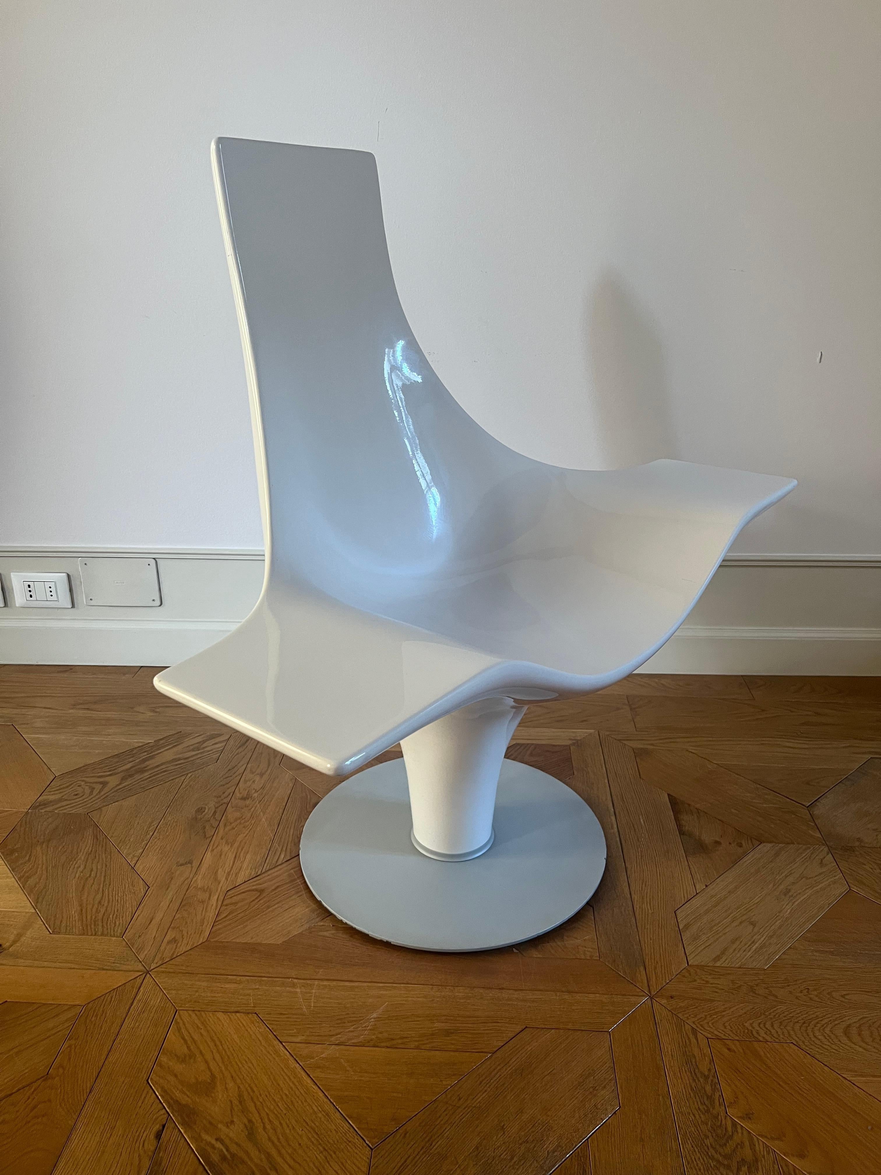 Armchair made from a single piece of reinforced fiberglass, bent and shaped to create the desired structure, giving it a sculptural appearance. The shell is white high gloss lacquered. Base in gray powder-coated metal in a circular shape. Designed