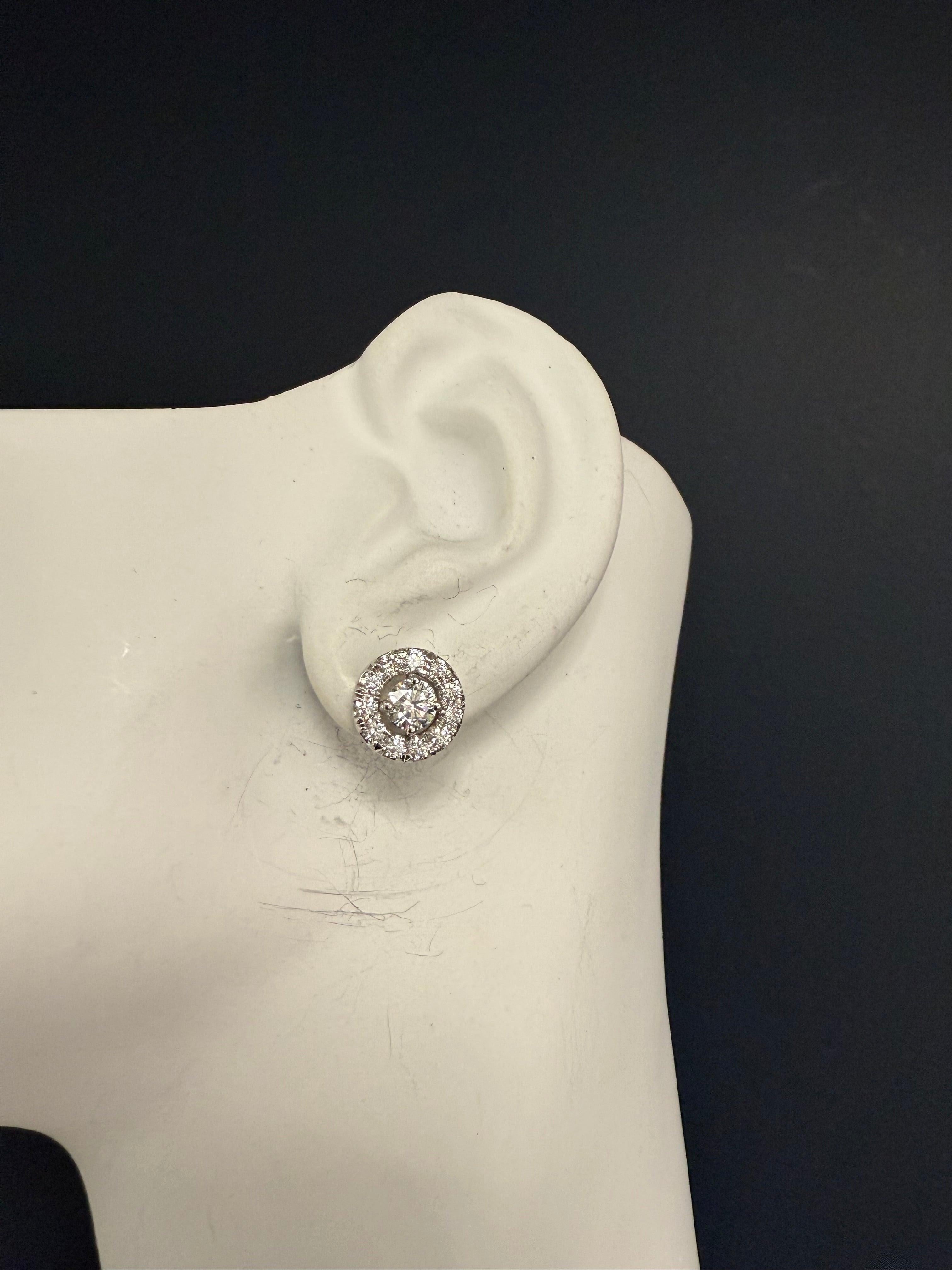 Elegant 2 Carat (appx total weight) 14K white gold halo stud earrings featuring two center round brilliant natural diamonds, each approximately 5.1 mm in diameter, G color and SI1 clarity. Surrounding each center stone are 22 natural round brilliant