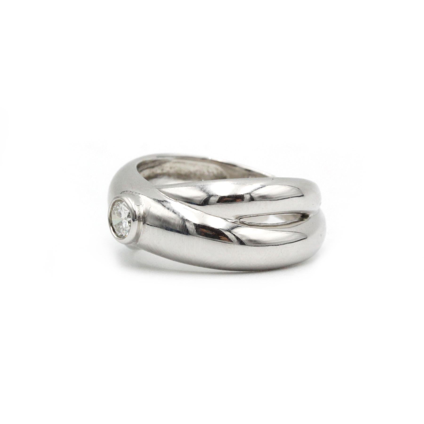 Découvrez l'élégance de cette bague croisée moderne en or blanc, réalisée en or blanc 18 carats (750‰). Cette pièce unique présente un design croisé fluide, embrassant gracieusement un diamant taille brillant d'environ 0,47 carat (G VS), solidement