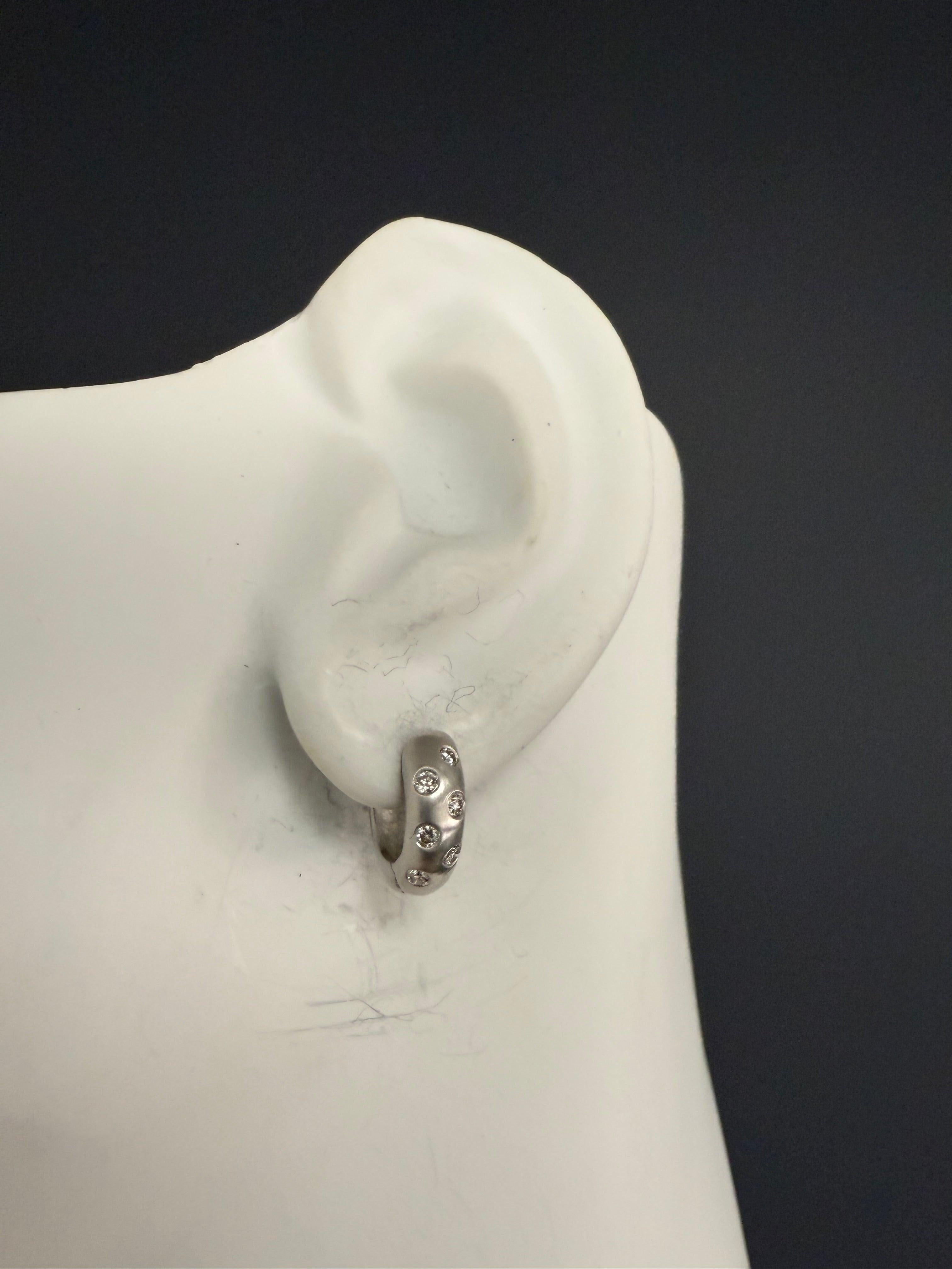 Moderne, satinierte Ohrringe aus Weißgold im Huggie-Stil mit insgesamt 0,30 Karat natürlichen, runden, farblosen Brillanten. Jeder Ohrring ist mit 12 Diamanten in Zargenfassung besetzt und wiegt insgesamt 4,9 Gramm. Sie haben einen Durchmesser von