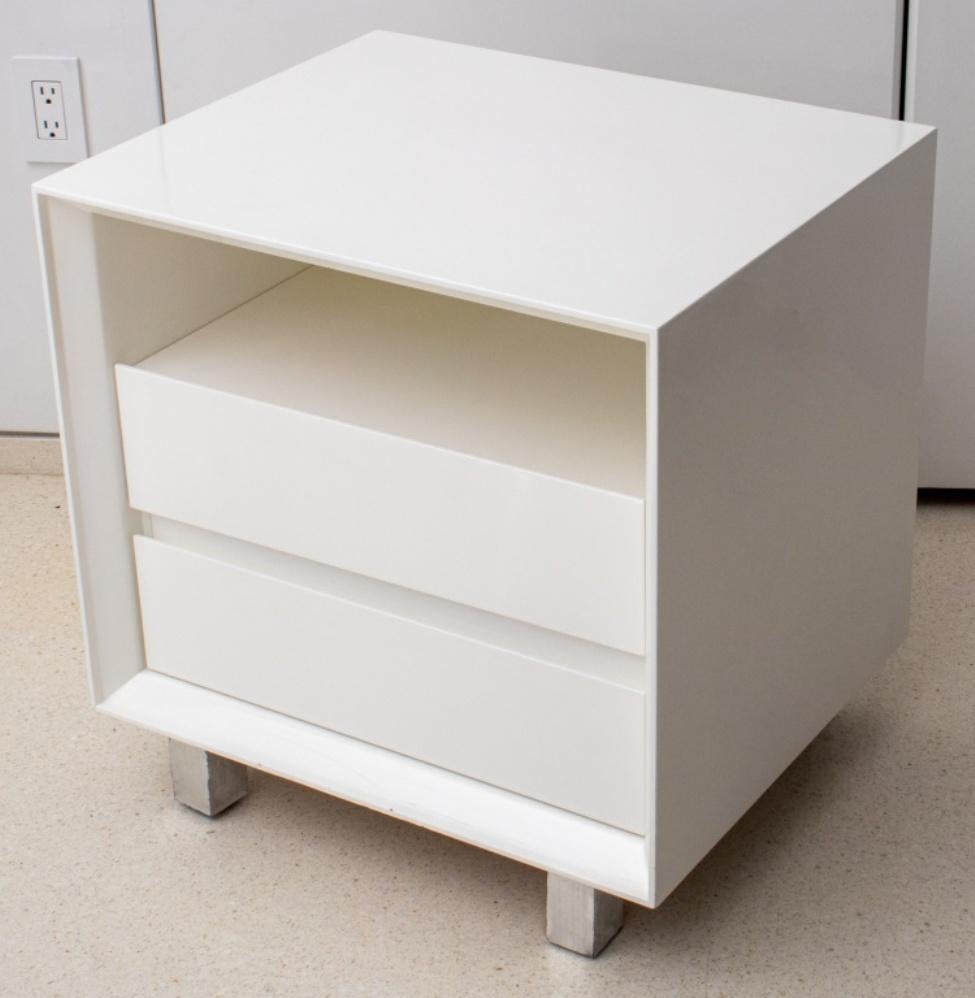 Paire de tables de chevet modernes en laque blanche avec une étagère au-dessus de deux tiroirs, chacune reposant sur quatre pieds en bois argenté.

Dimensions : Chaque :  24,25