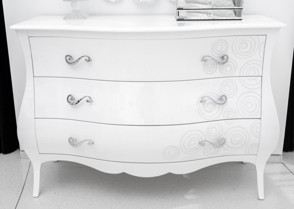 Modern white lacquered bombe chest with three drawers and swirling design, the gem-set silver-tone metal pulls of spiral form. 36